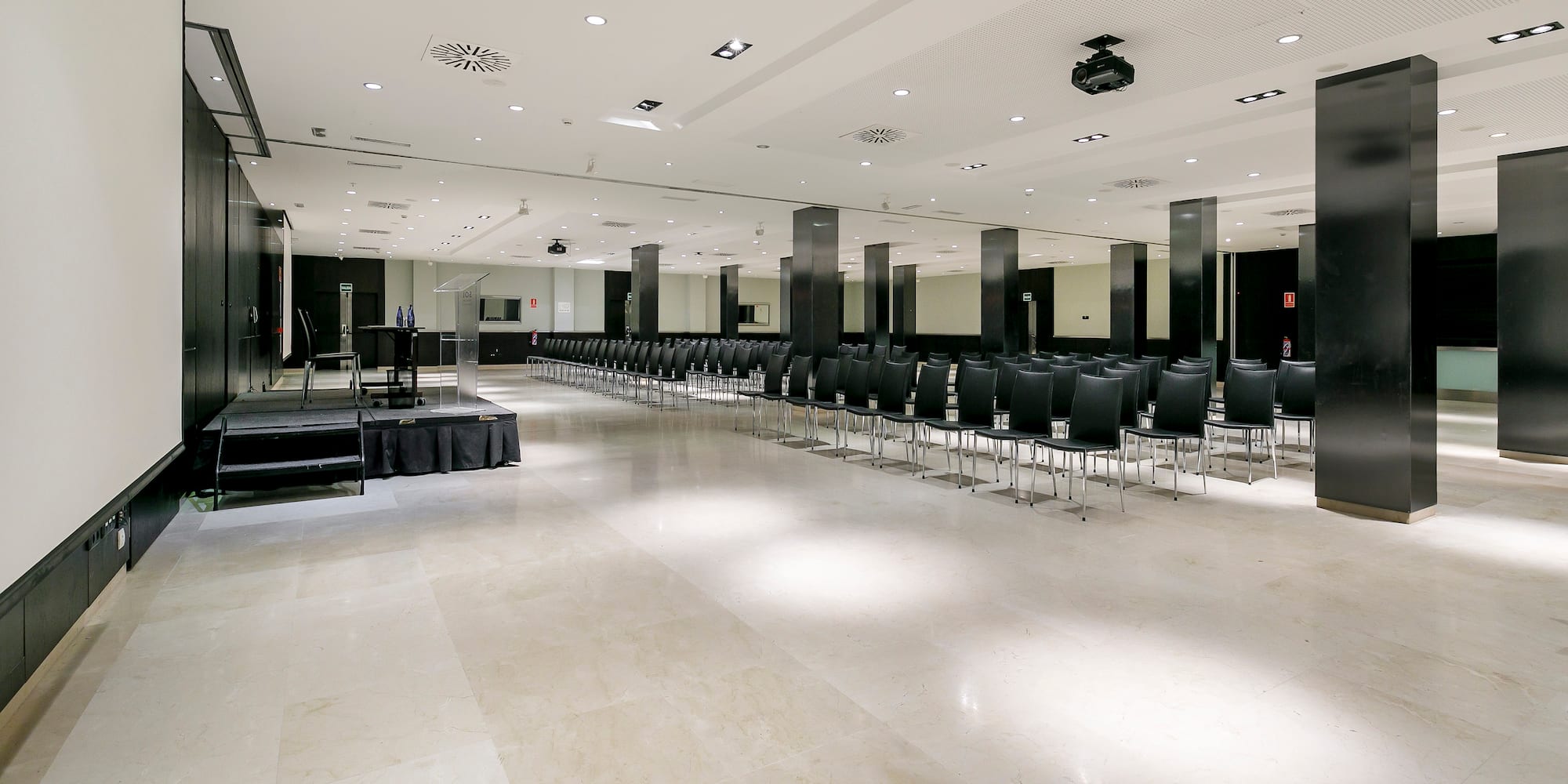 a room with black chairs and a stage