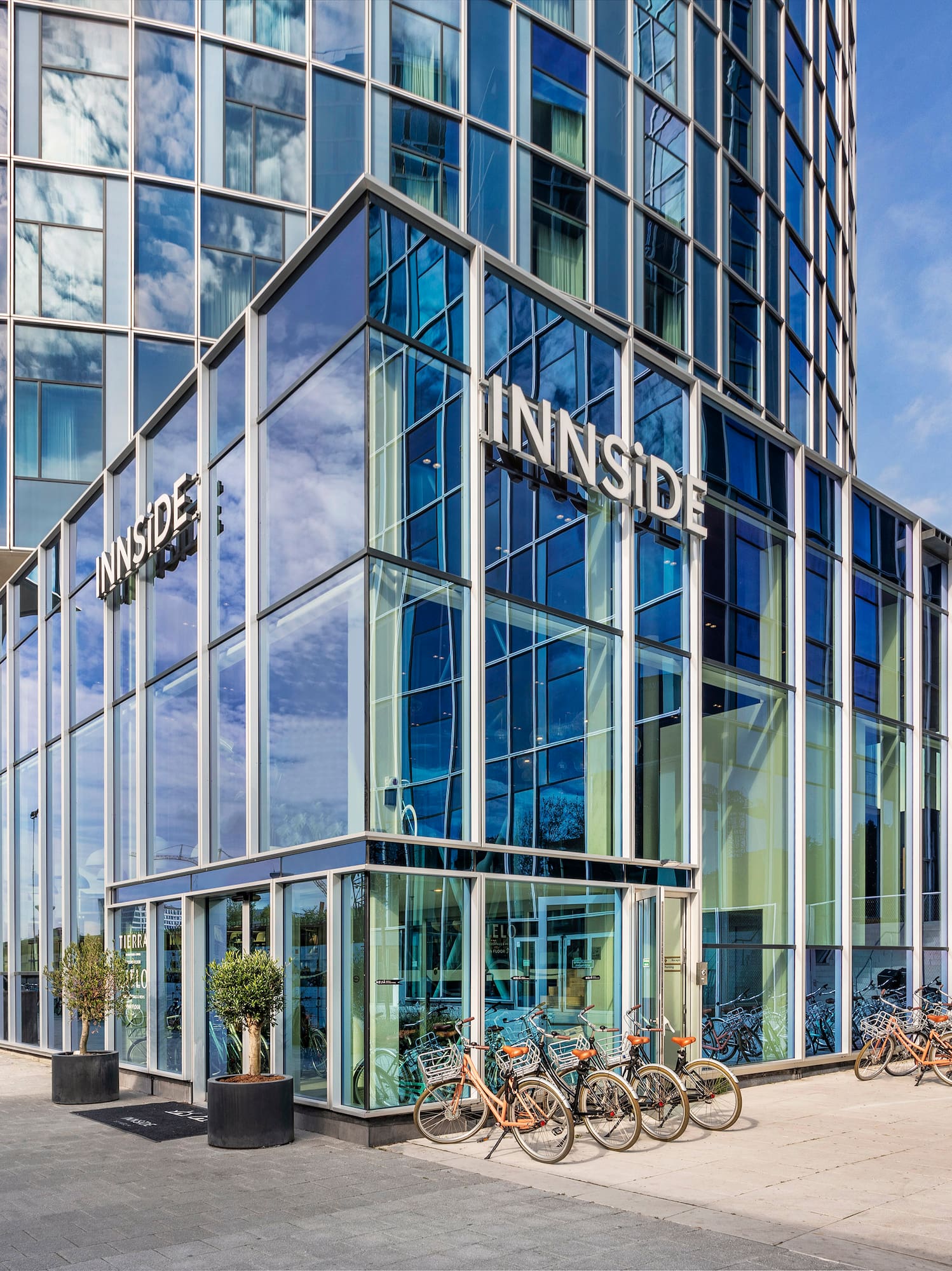 a glass building with a lot of bicycles parked in front of it