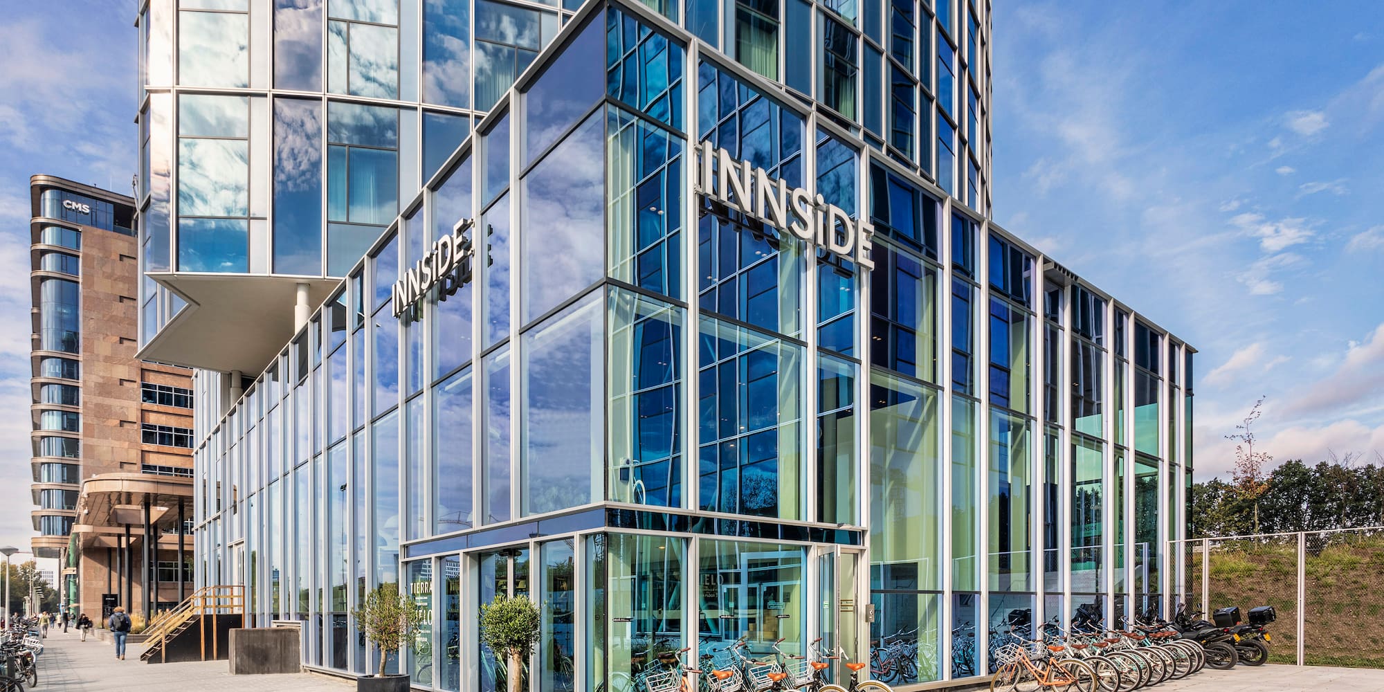 a glass building with a lot of bicycles parked in front of it