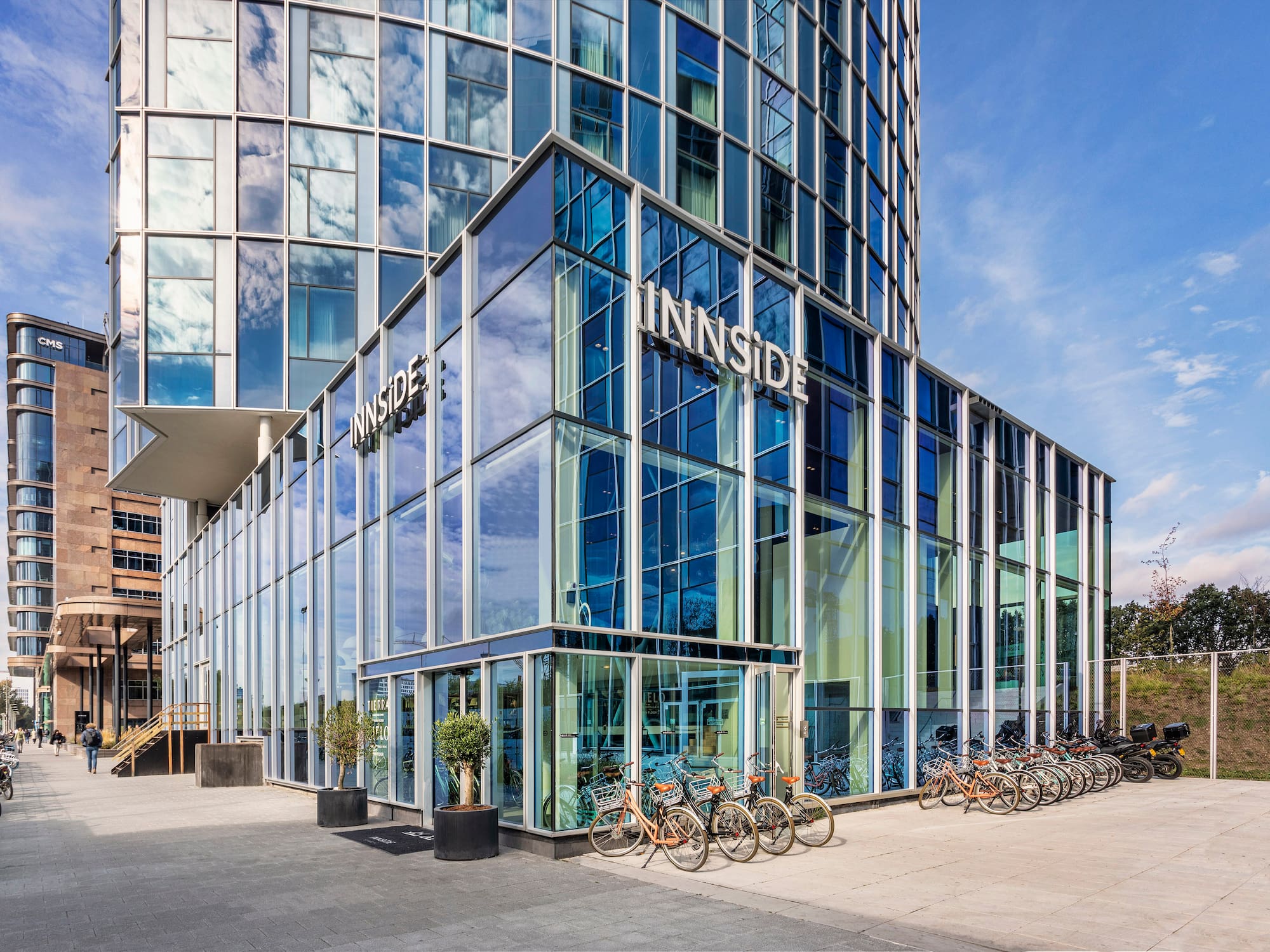 a glass building with a lot of bikes parked in front of it