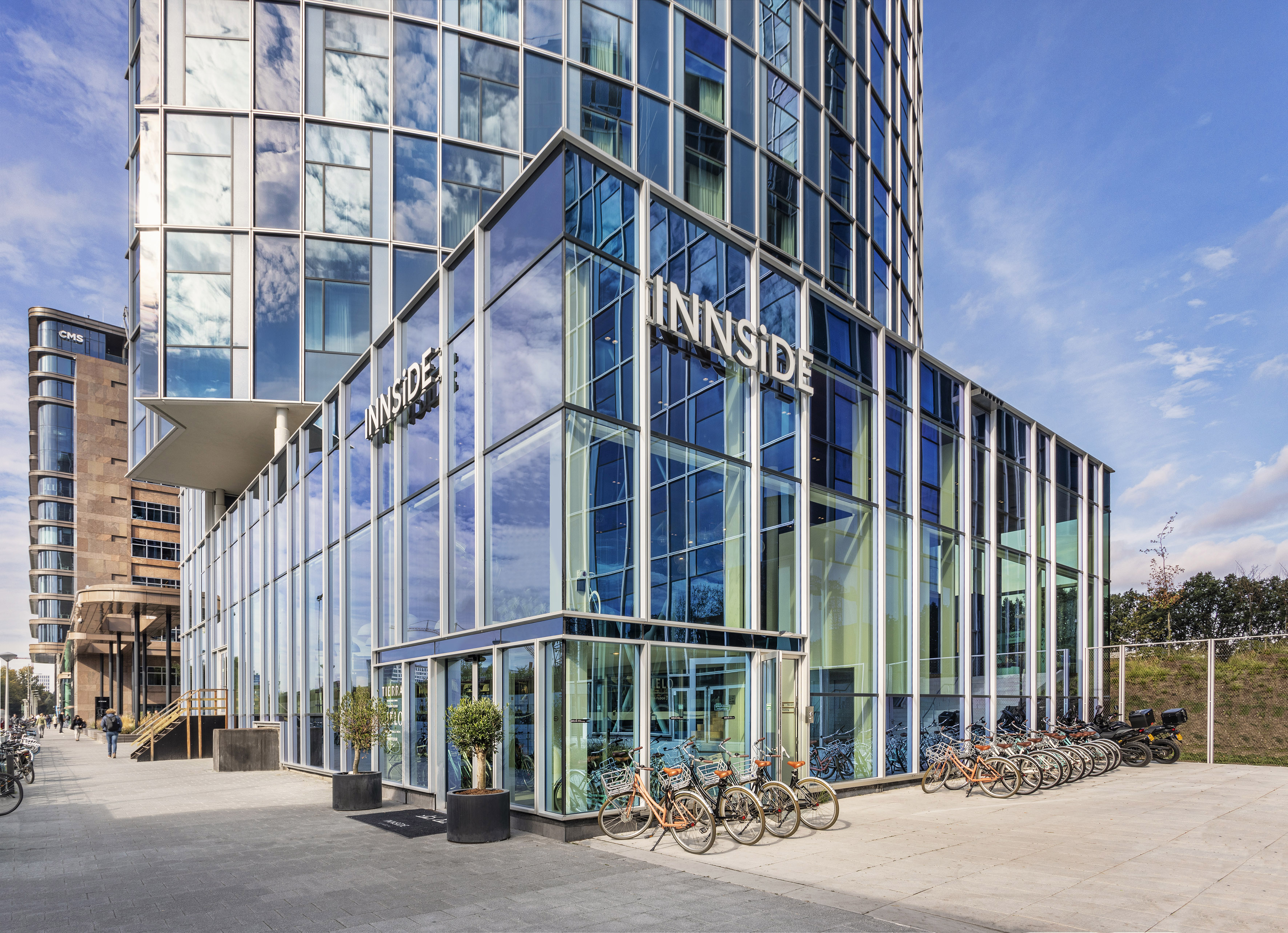 a glass building with a lot of bikes parked in front of it