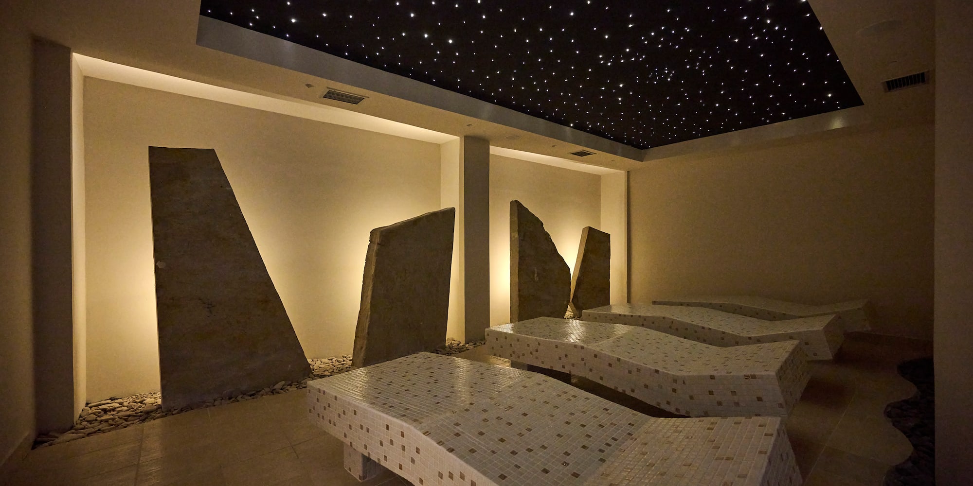 a room with a black ceiling and white beds