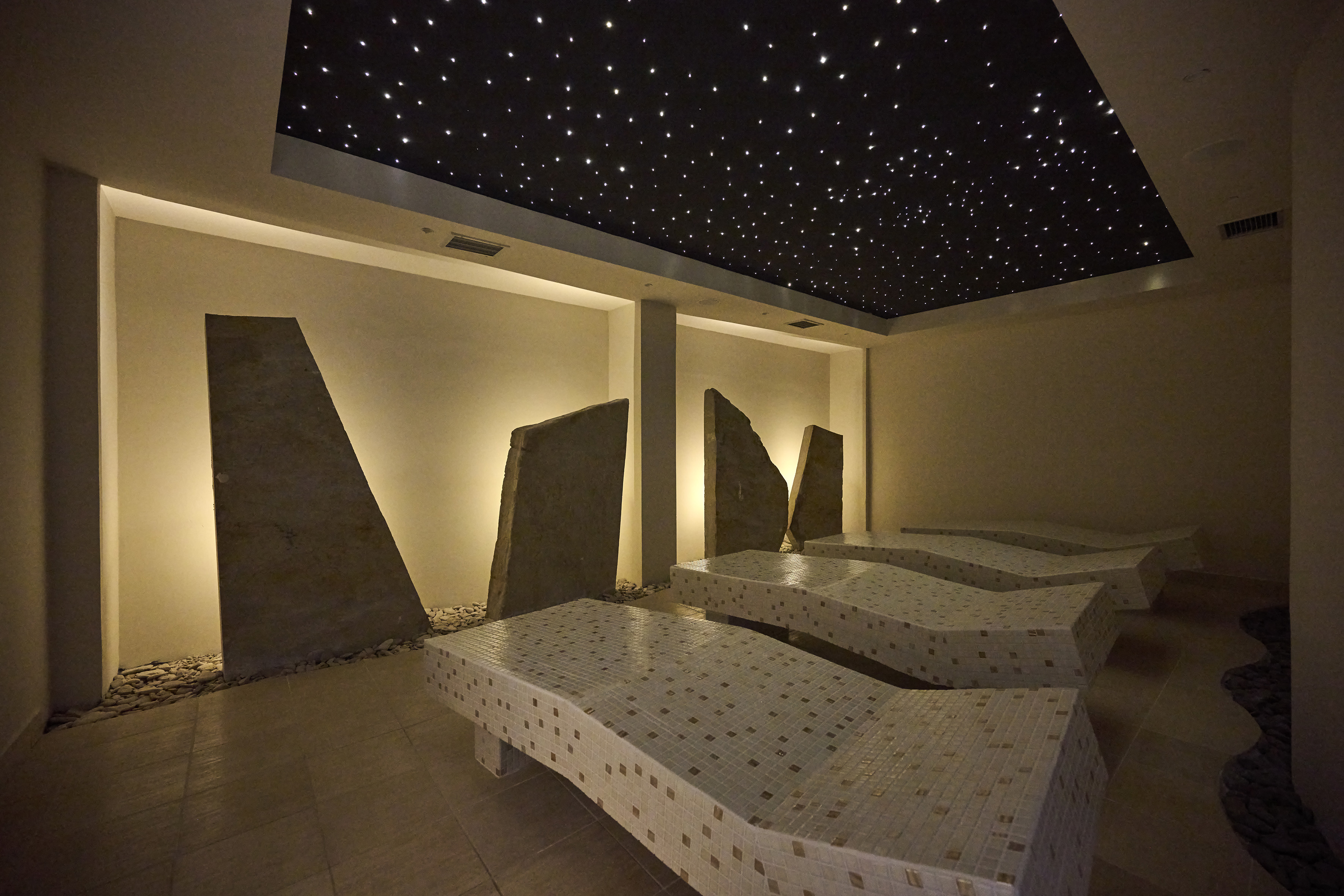 a room with a black ceiling and white beds