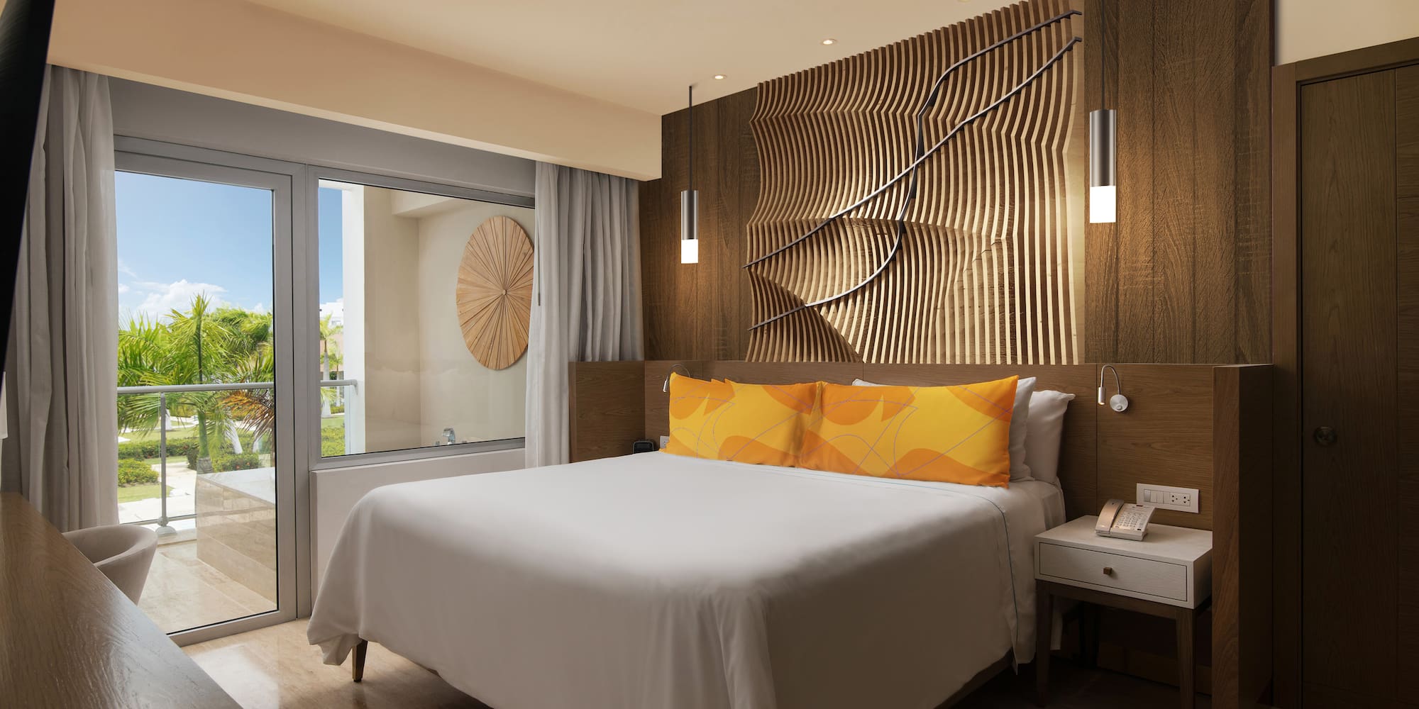 a bed with a white bed and a table with a glass door