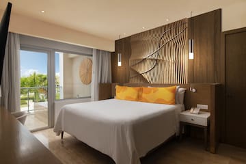 a bed with a white bed and a table with a glass door