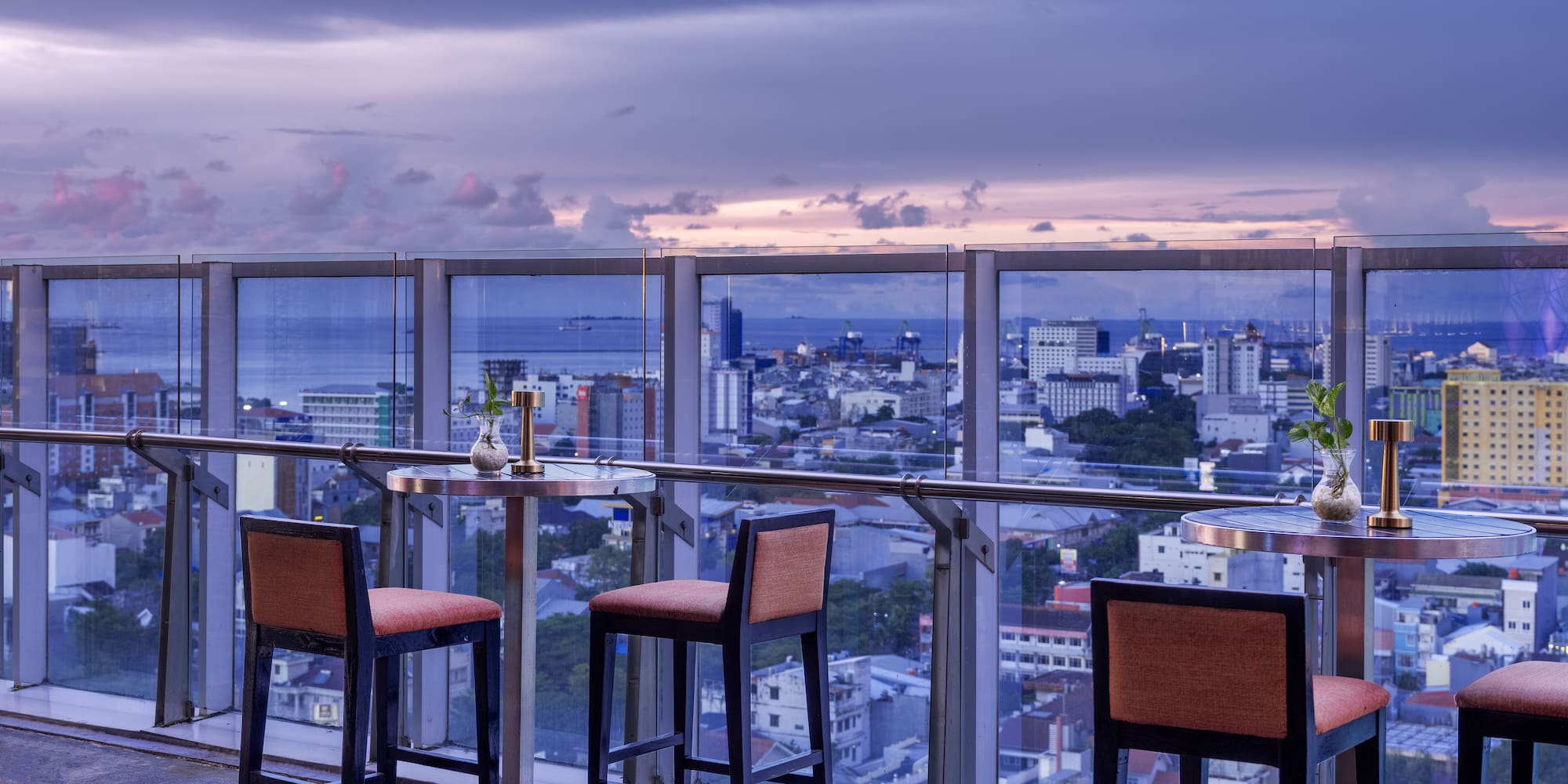a table and chairs on a balcony overlooking a city