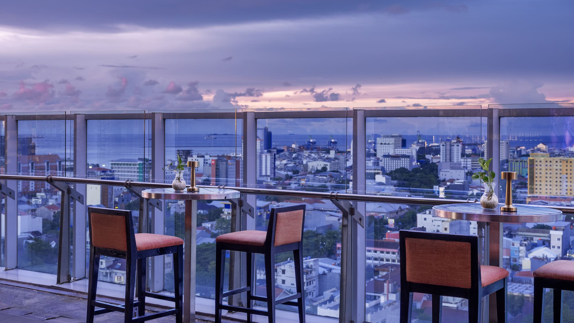 a table and chairs on a balcony overlooking a city