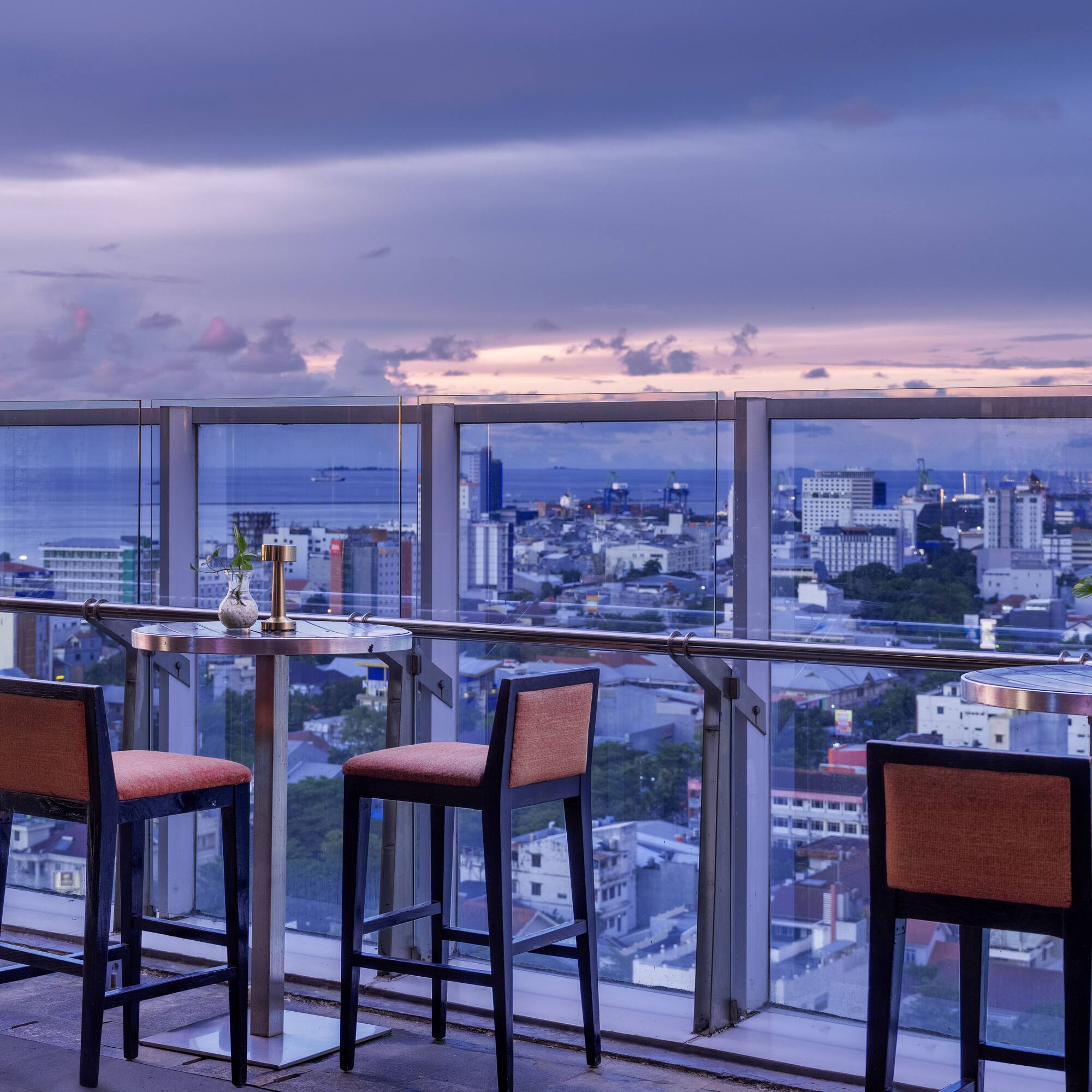 a table and chairs on a balcony overlooking a city