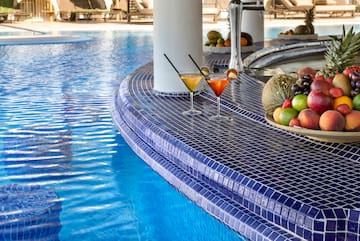 a pool with a bowl of fruit and a plate of fruit on the side