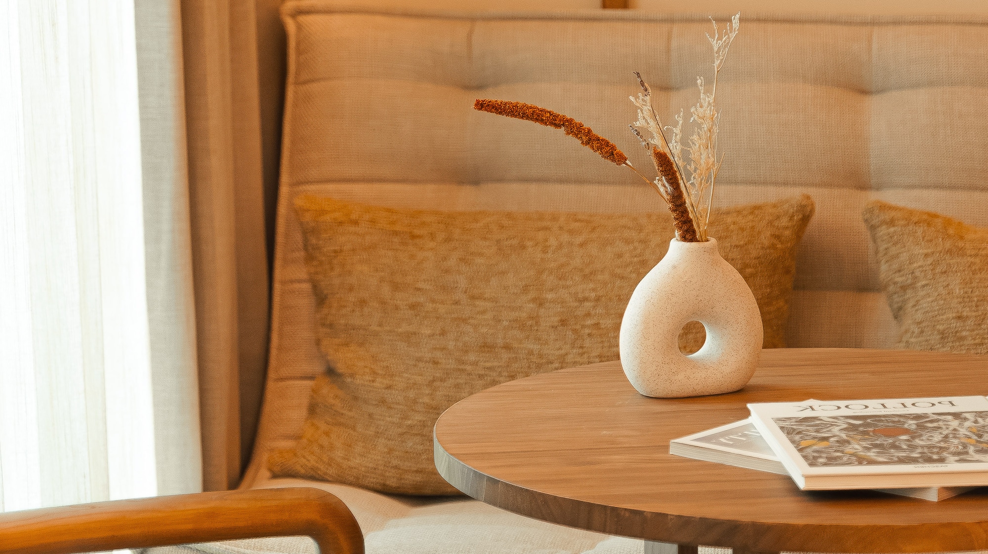 a table with a vase of dry flowers on it