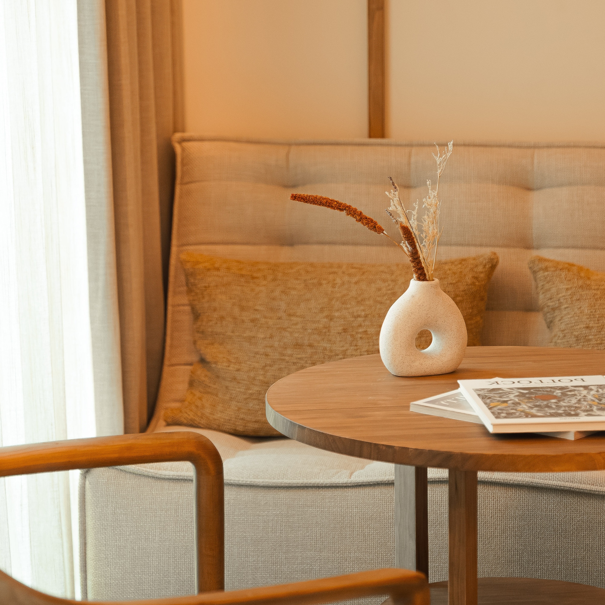 a table with a vase of dry flowers on it