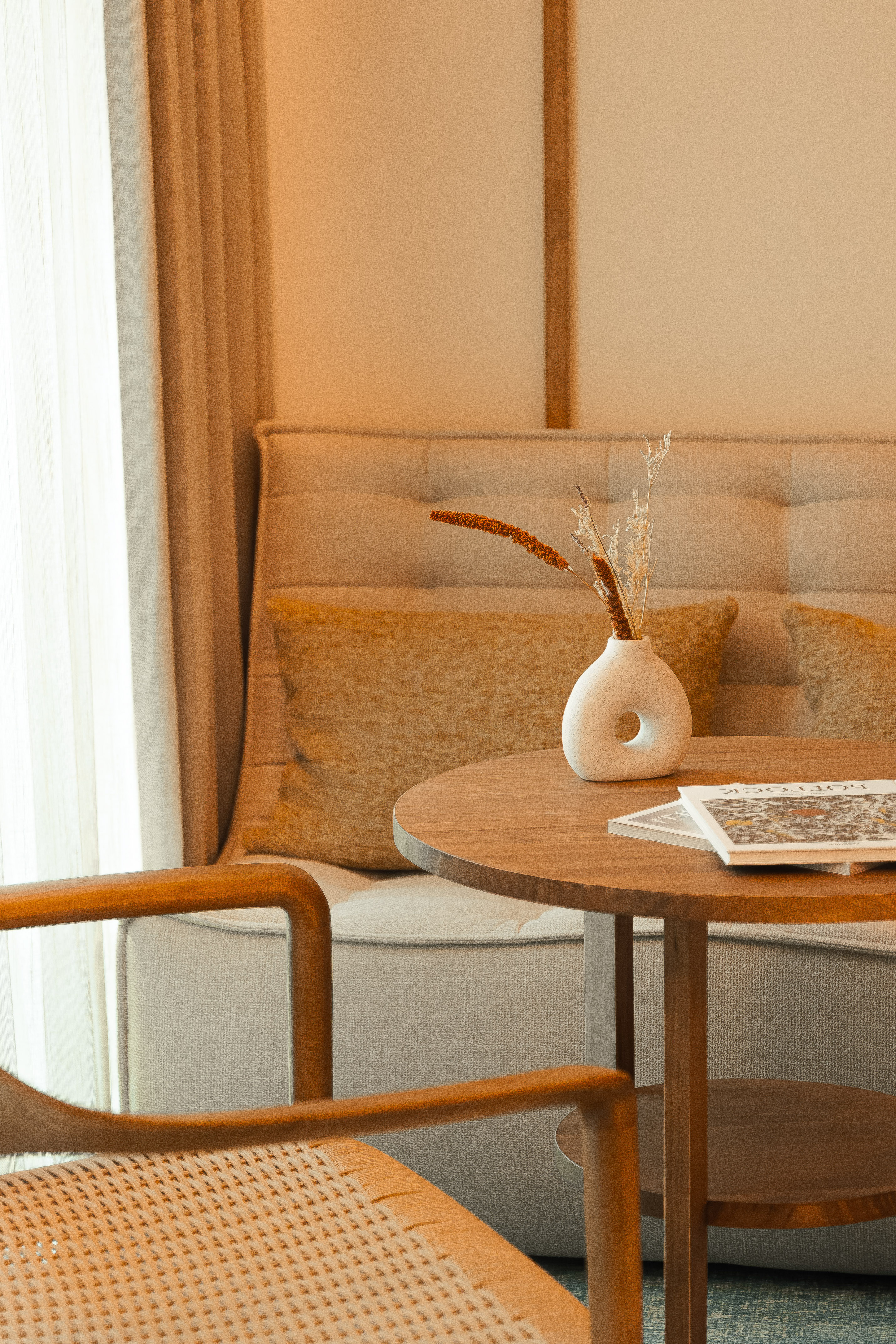 a table with a vase of dry flowers on it