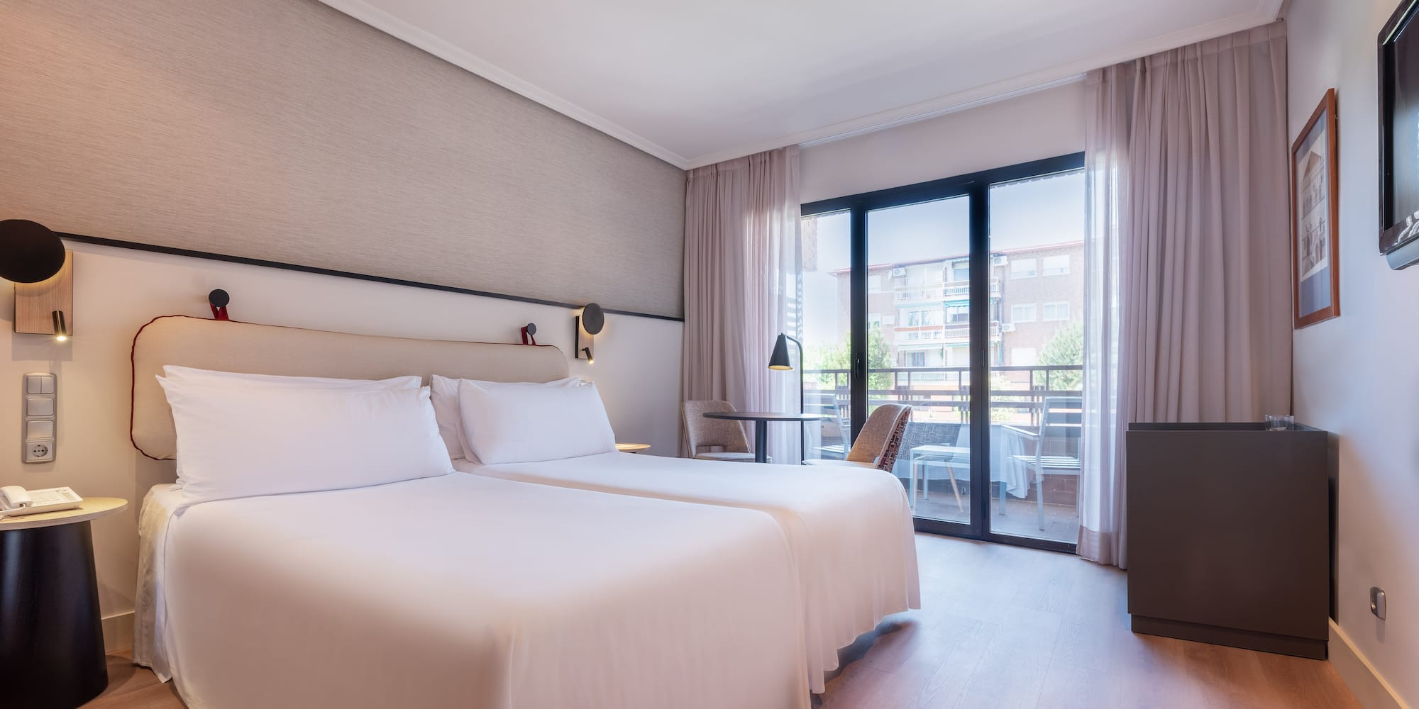 a room with two beds and a table and chairs