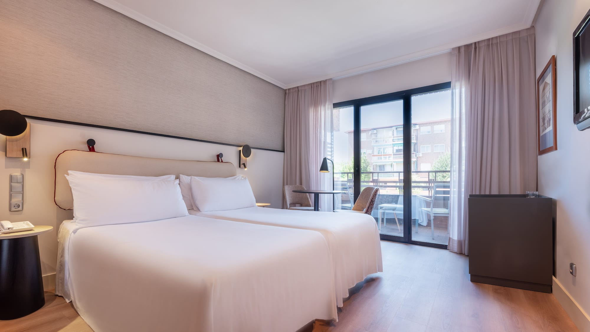 a room with two beds and a table and chairs