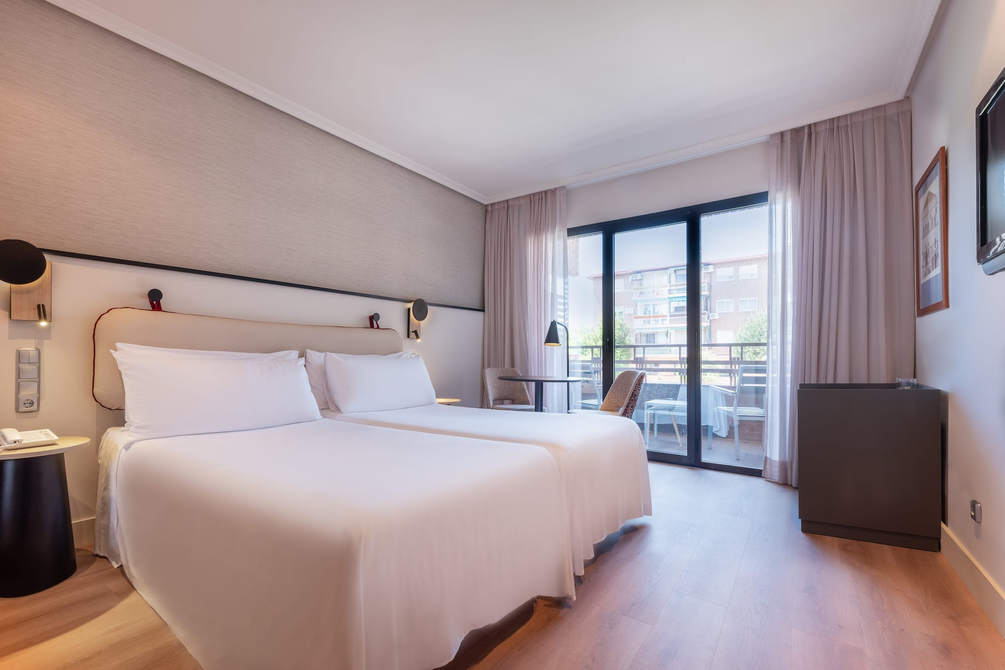 a room with two beds and a table and chairs