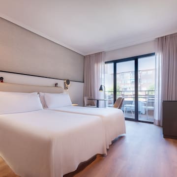 a room with two beds and a table and chairs