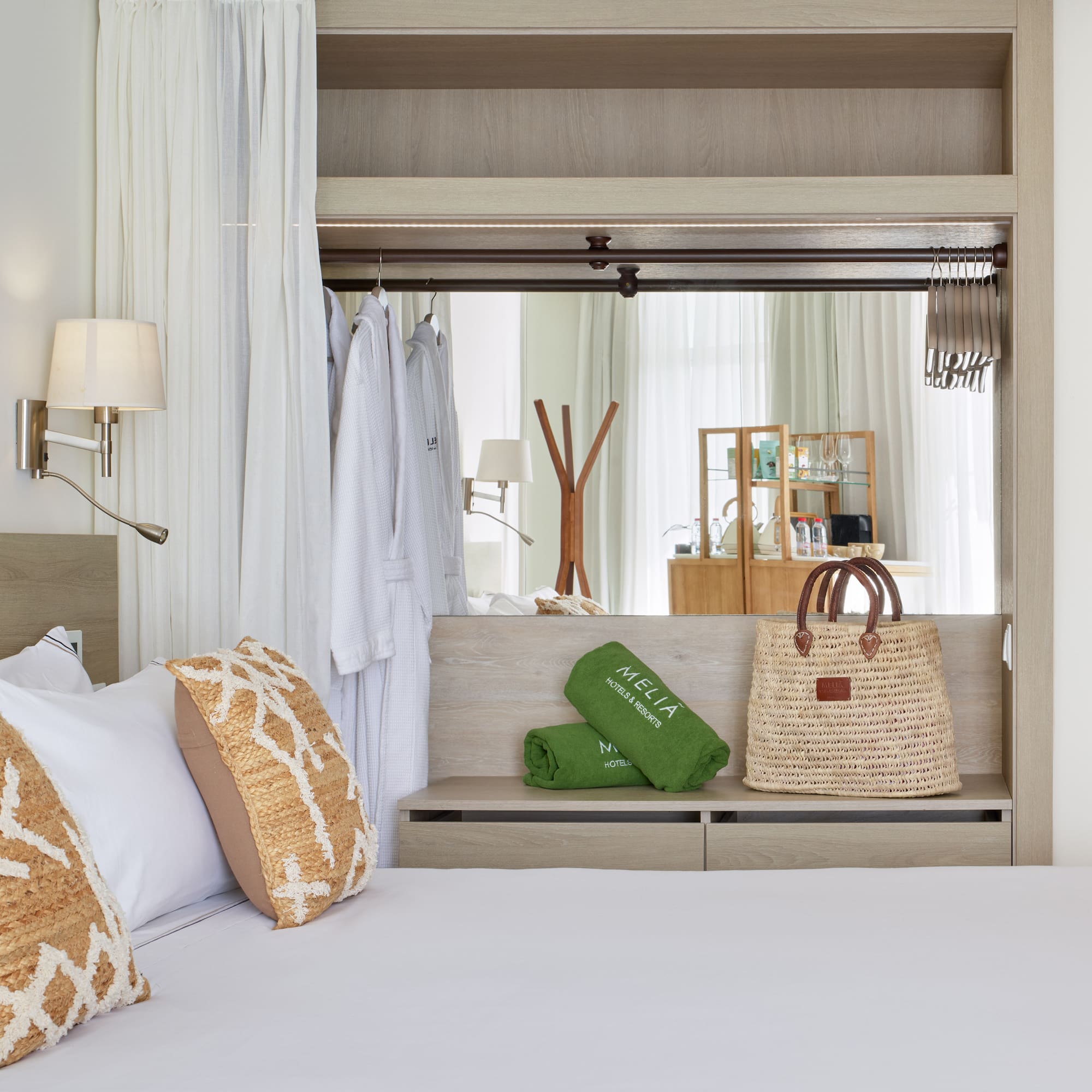 a bed with white sheets and brown pillows