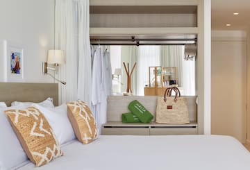 a bed with white sheets and brown pillows