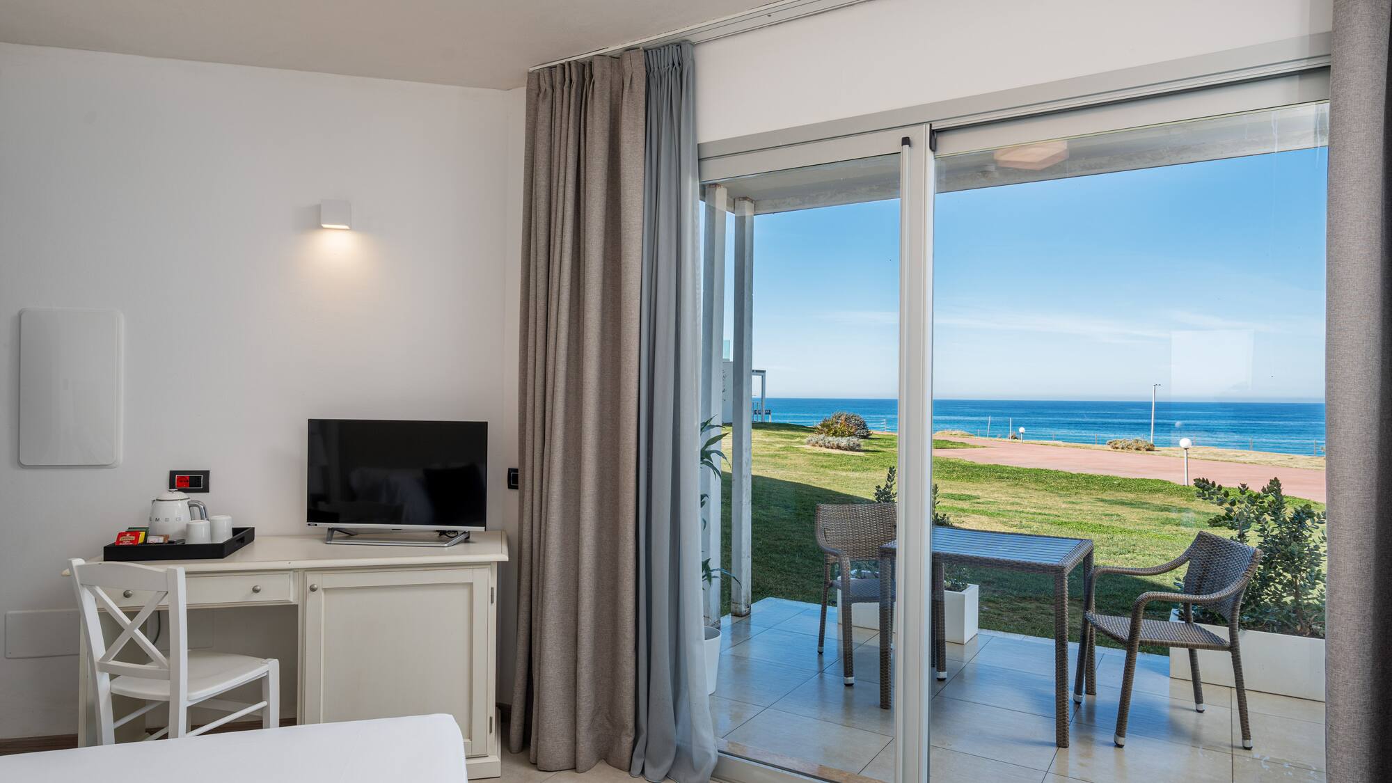a room with a sliding glass door and a table and chairs