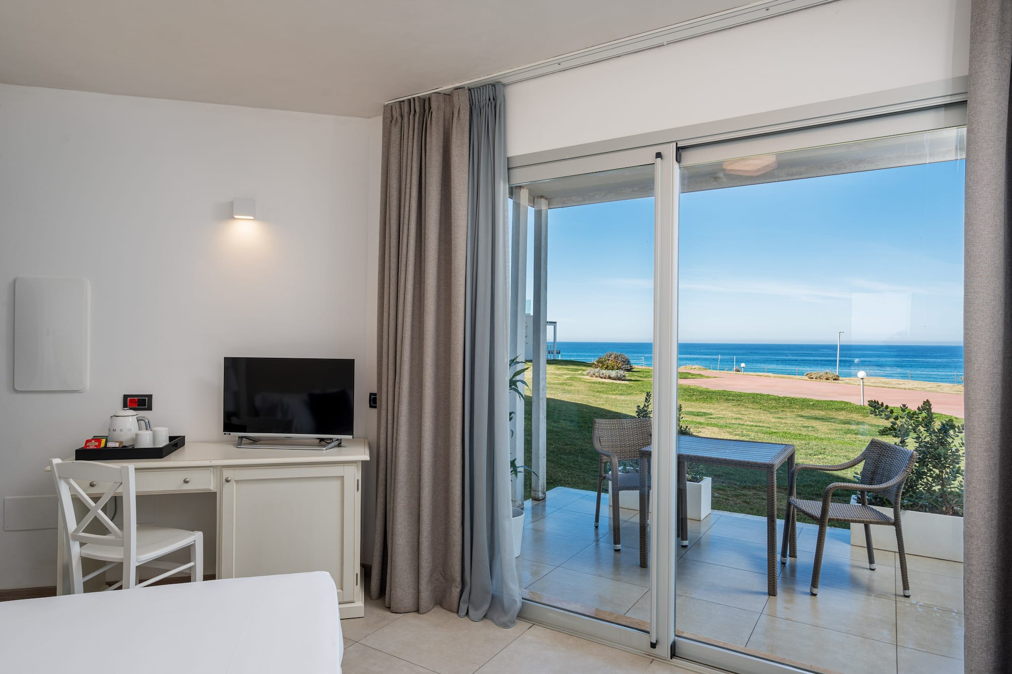 a room with a sliding glass door and a table and chairs
