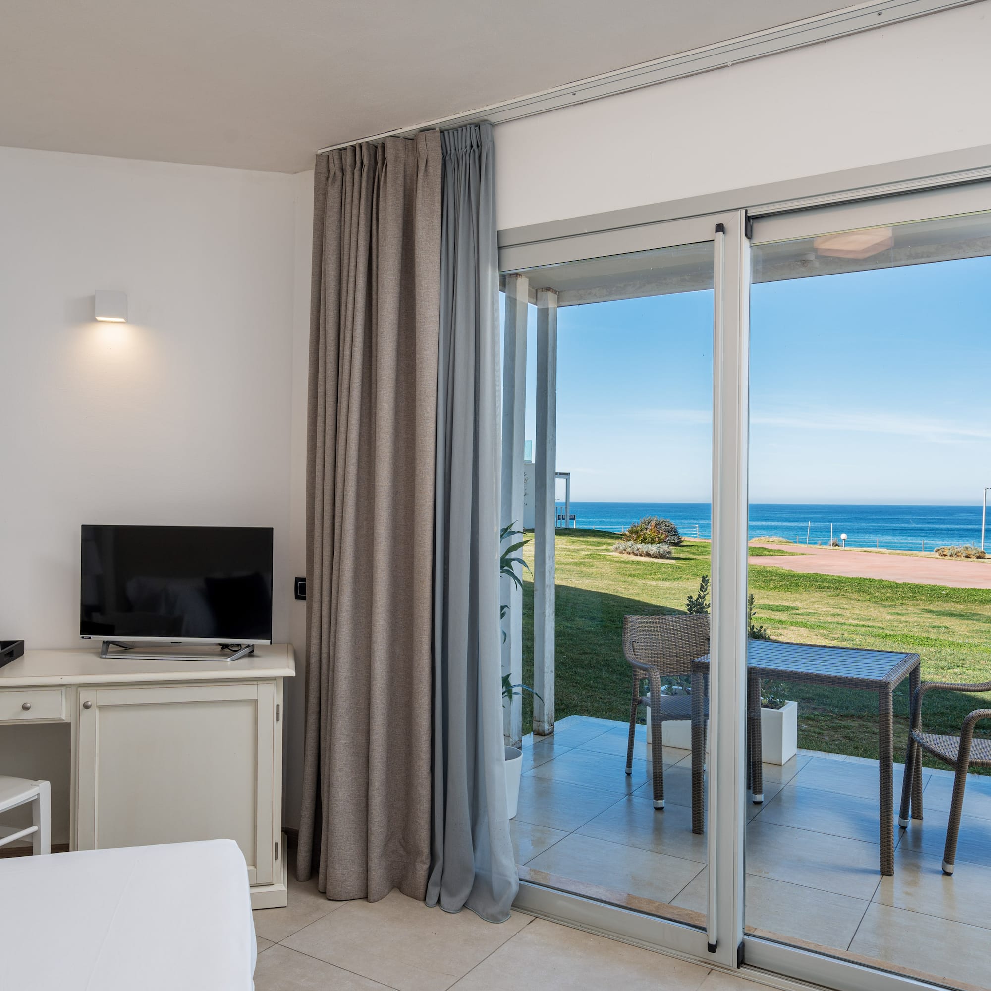 a room with a sliding glass door and a table and chairs