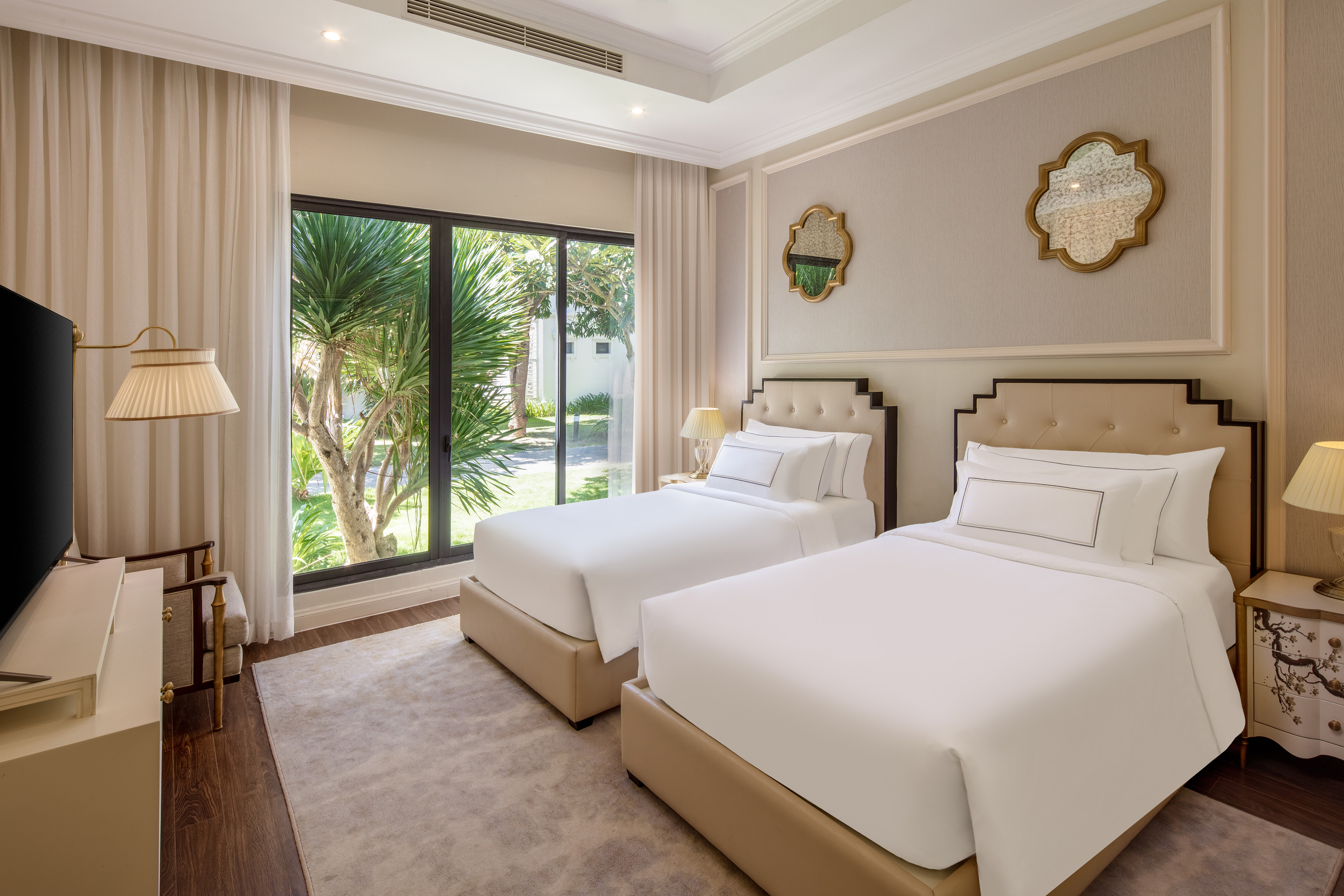 Modern twin hotel room with garden view and elegant decor.