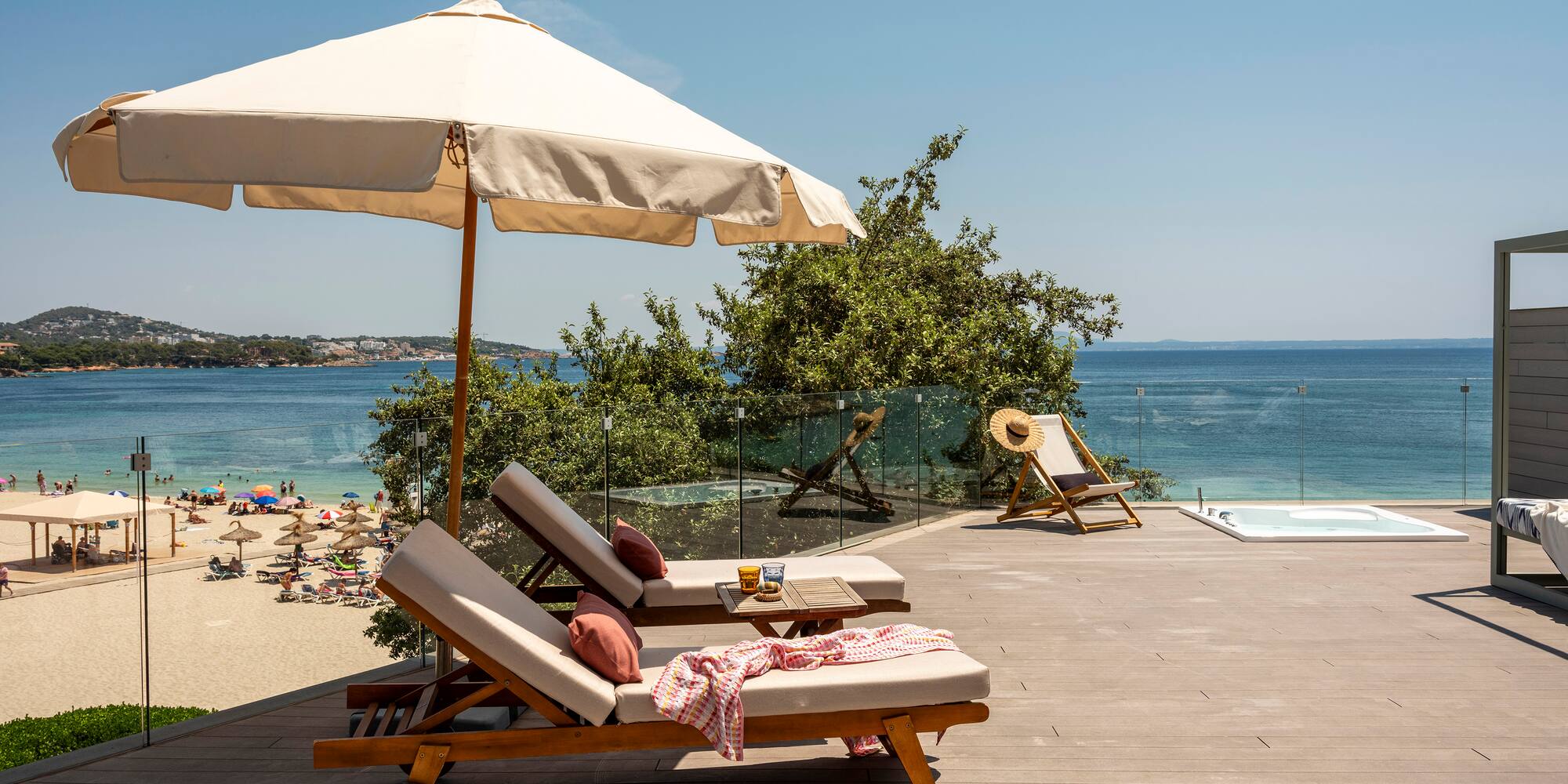 a deck with chairs and umbrella on a beach