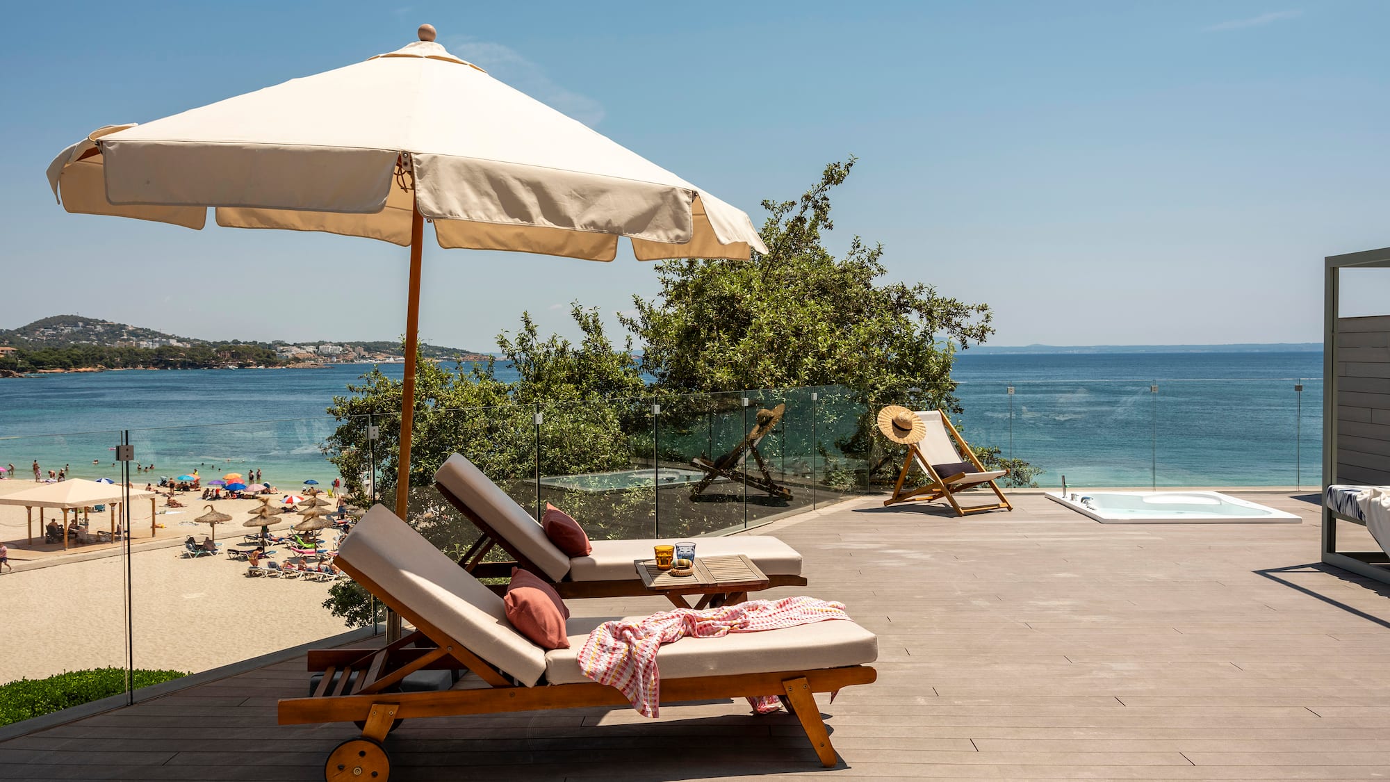 a deck with chairs and umbrella on a beach
