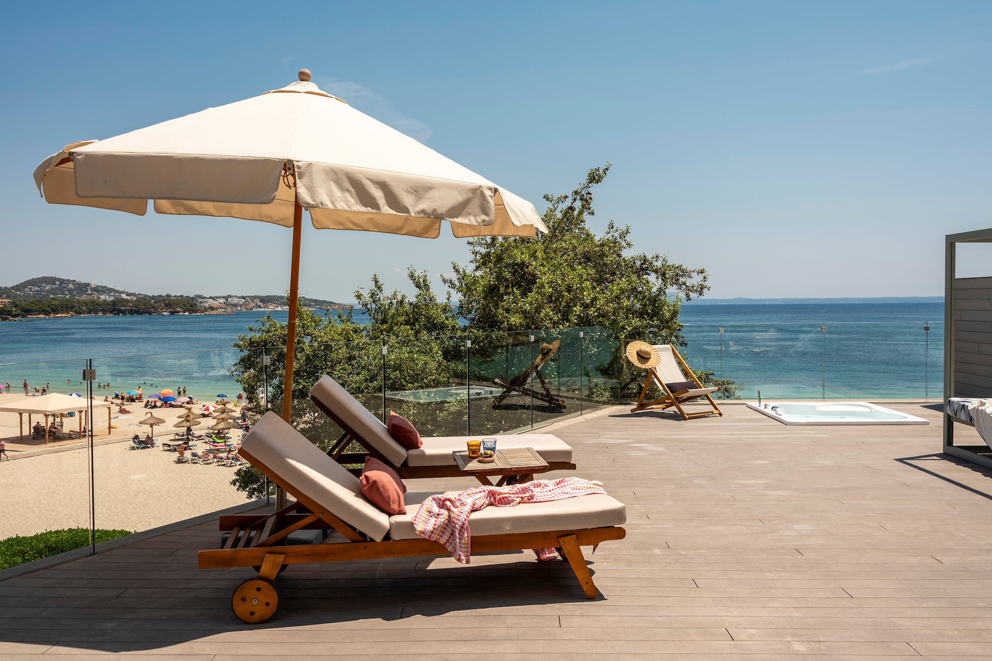 a deck with chairs and umbrella on a beach