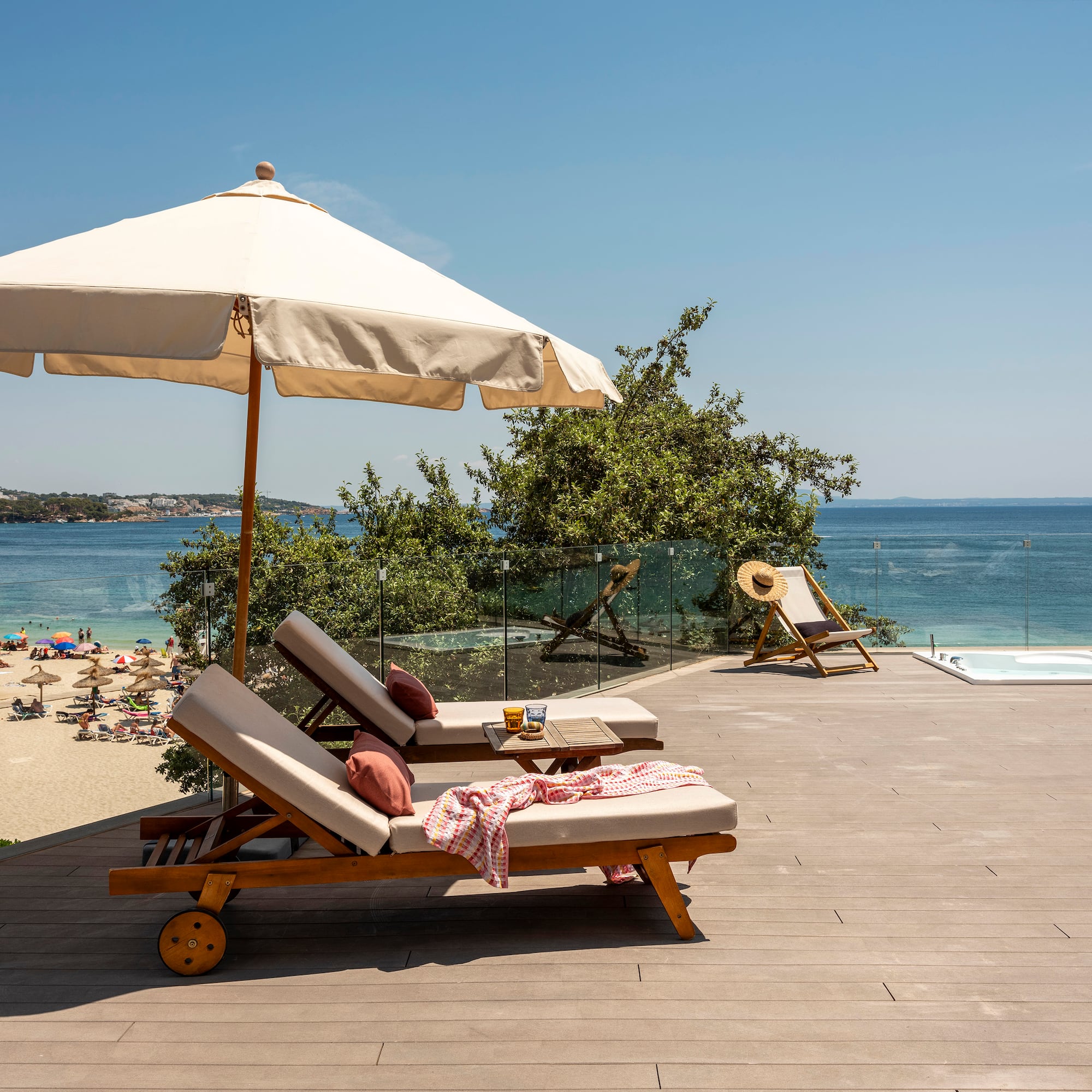 a deck with chairs and umbrella on a beach