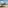 Ocean view deck with sun loungers, umbrella, jacuzzi, and sandy beach below.