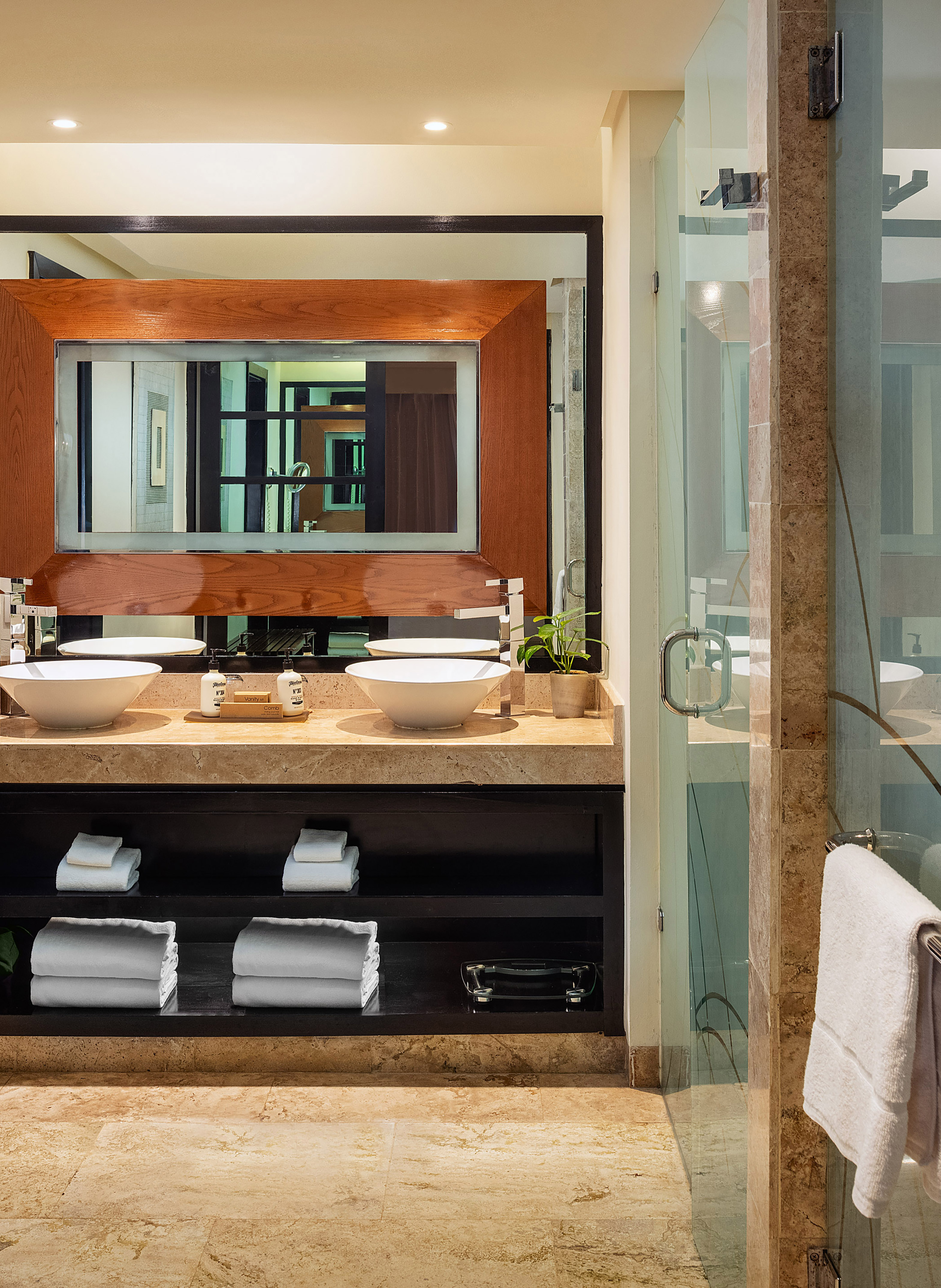 Modern bathroom double vanity with vessel sinks and wooden framed mirror.