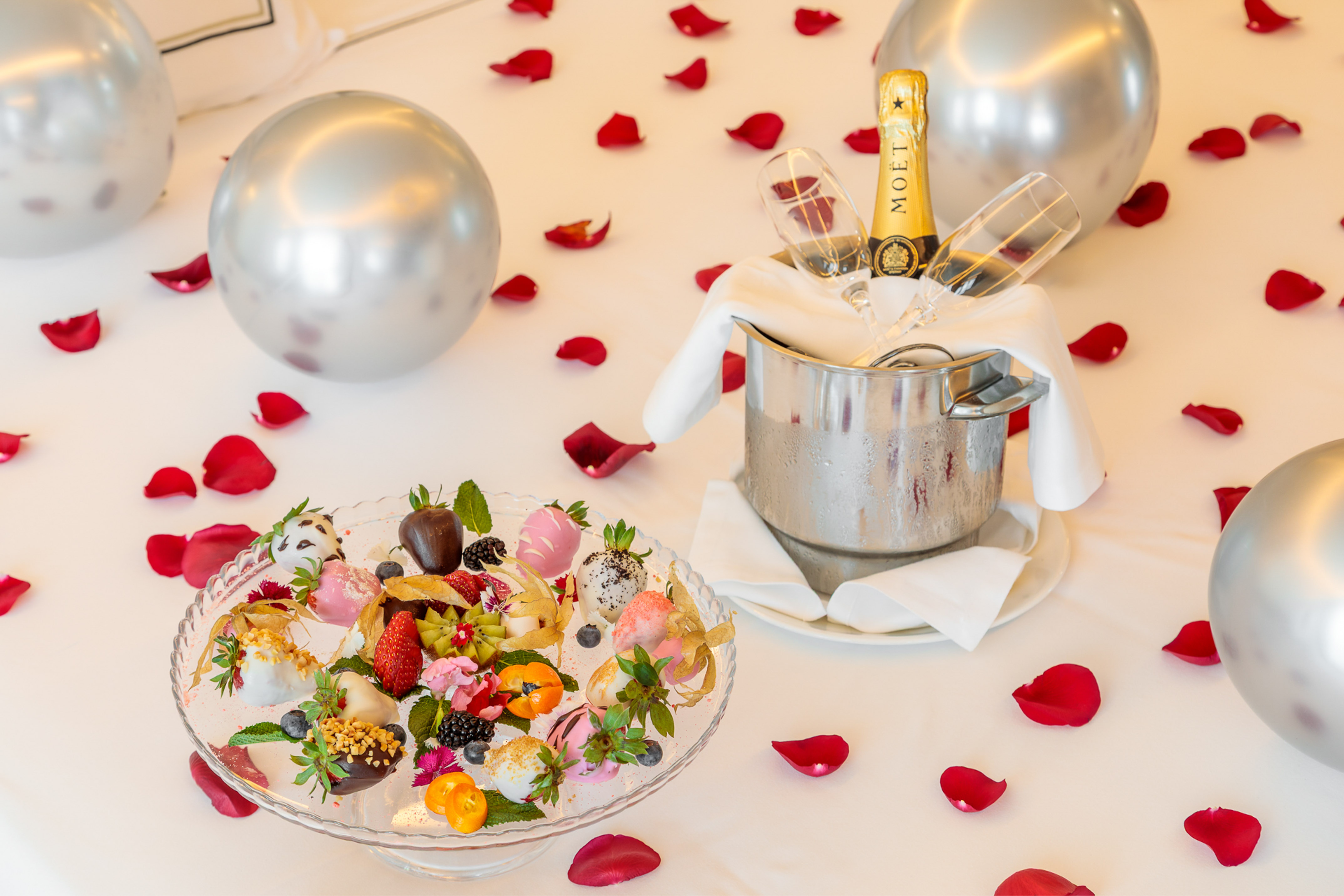a champagne bottle and fruit in a bucket on a table