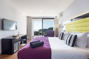 a bedroom with a purple bed and a purple chair