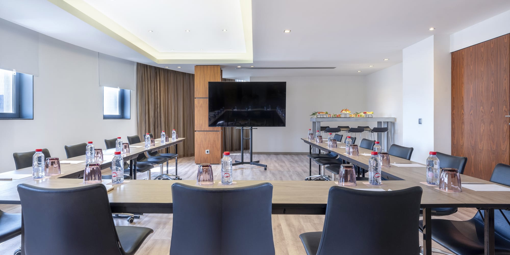 a room with tables and chairs and a television