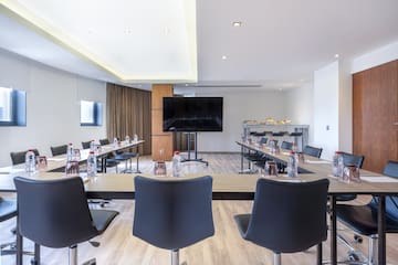 a room with tables and chairs and a television