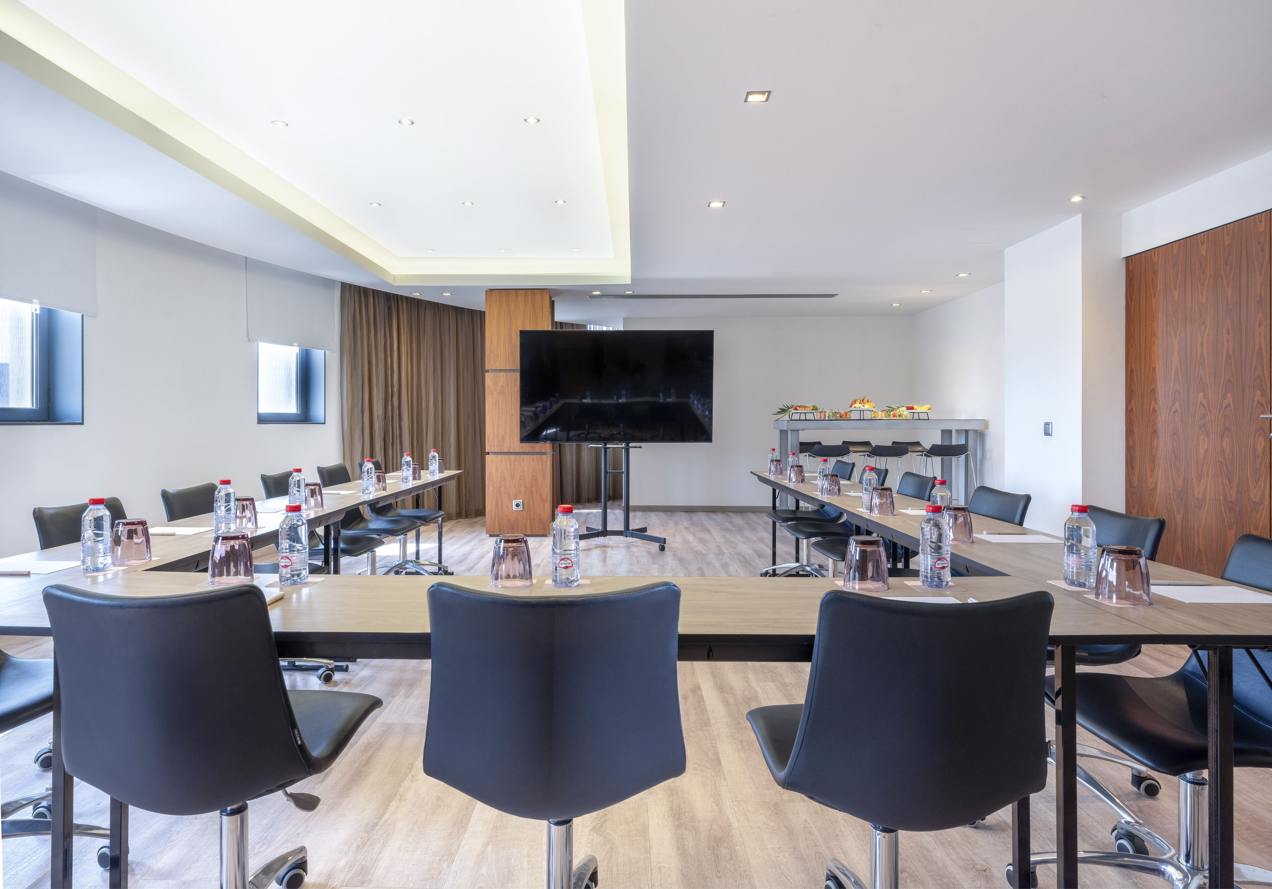 a room with tables and chairs and a television