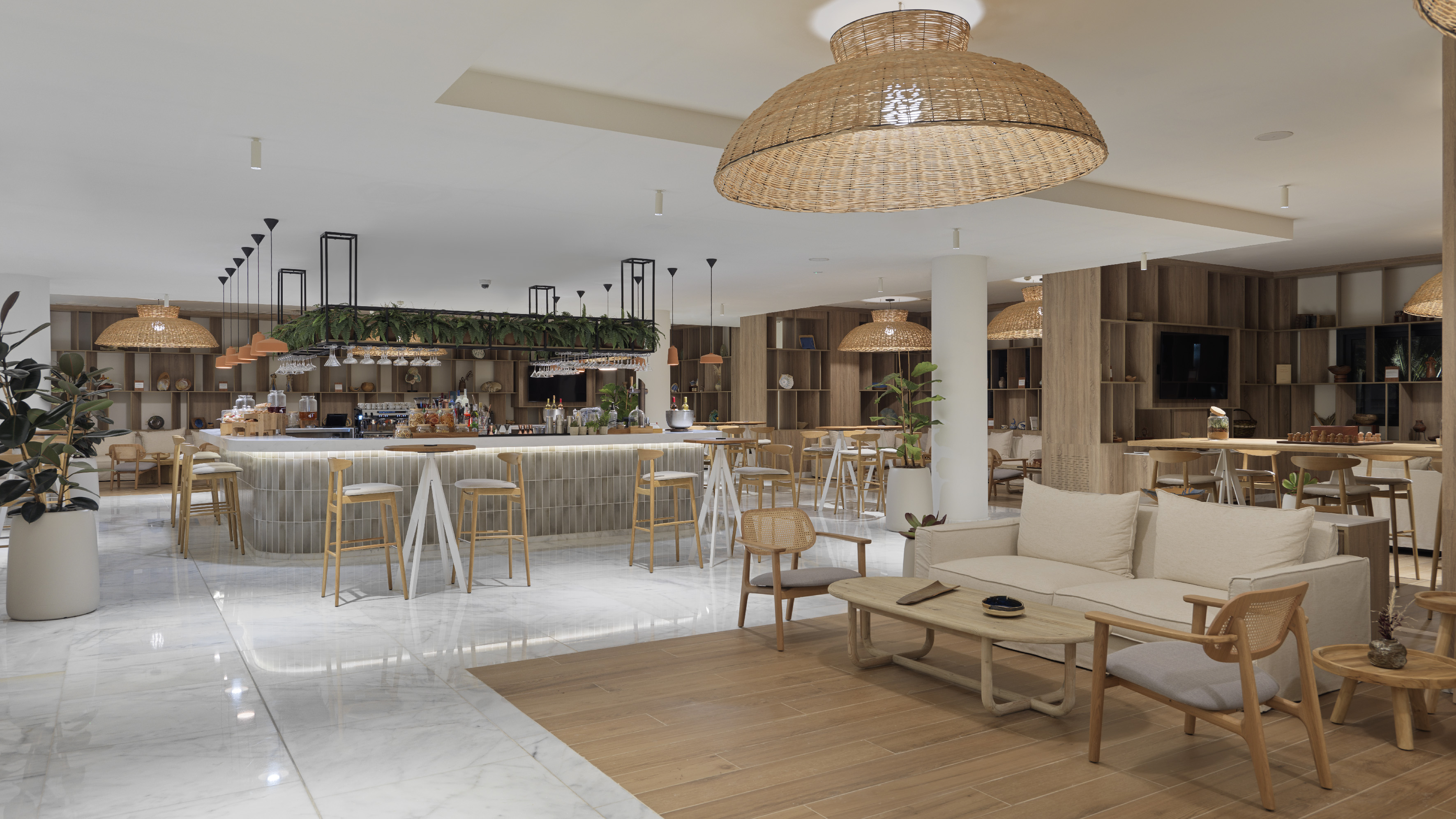 Modern resort bar with natural wood, wicker lights, and lush plant decor.