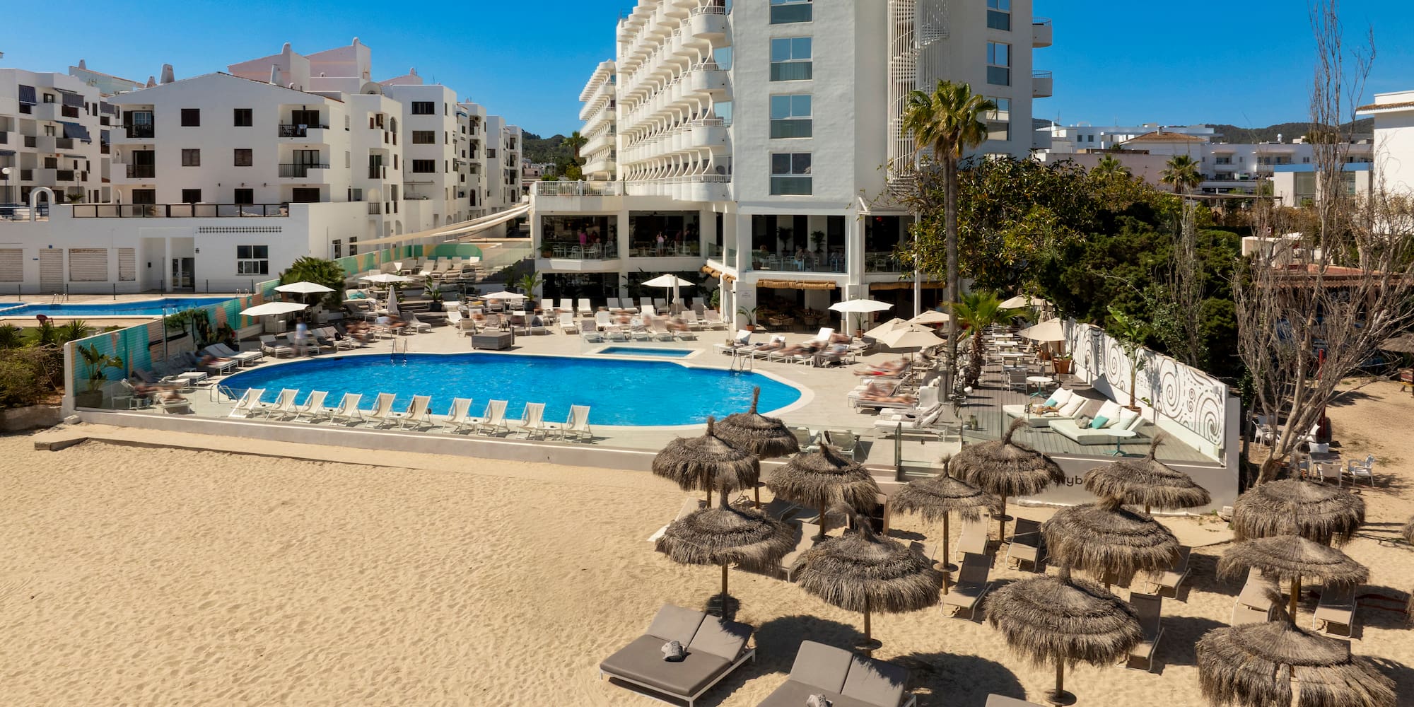 a pool and umbrellas on a beach
