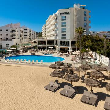 a pool and umbrellas on a beach
