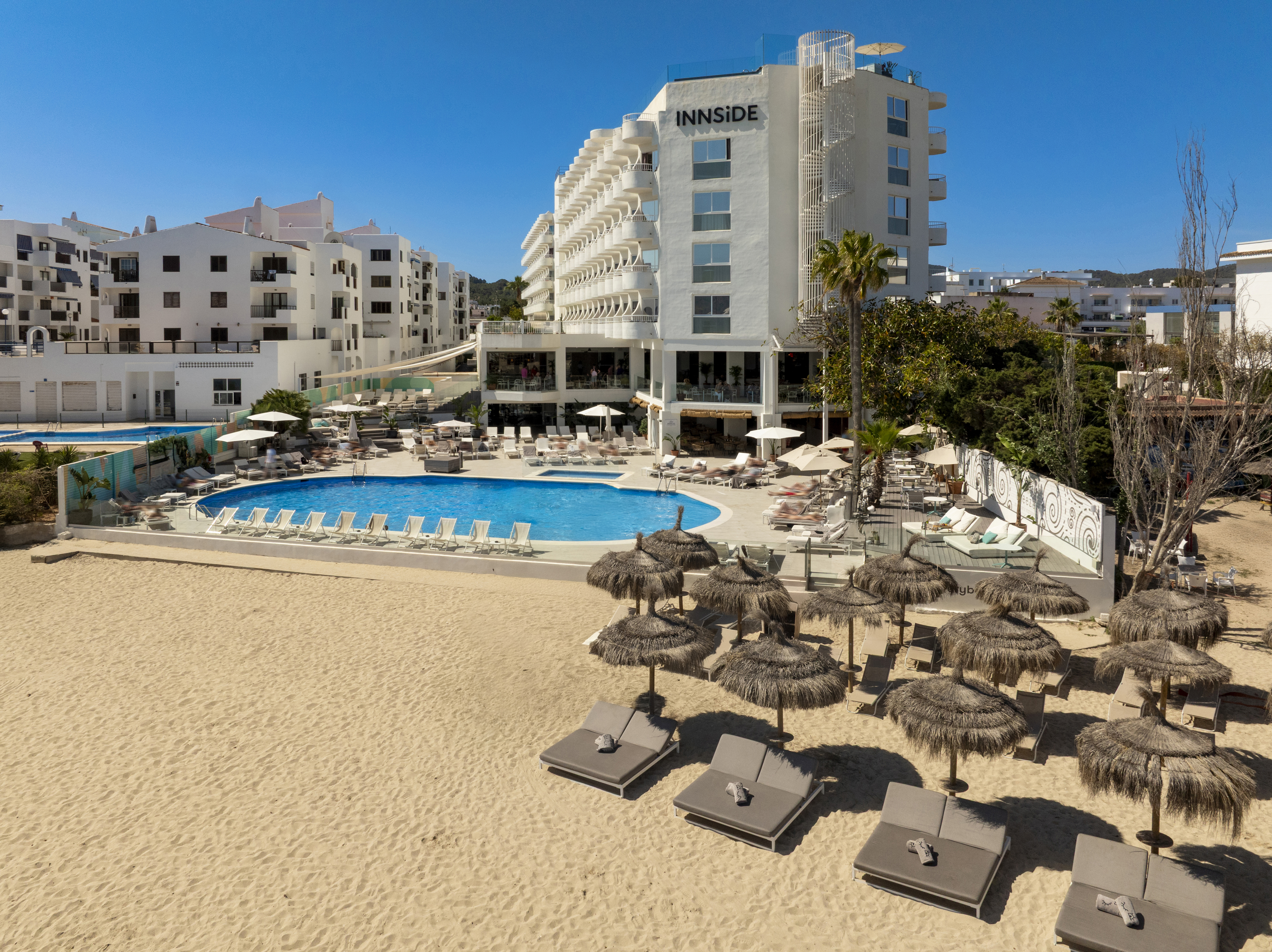 a pool and umbrellas on a beach