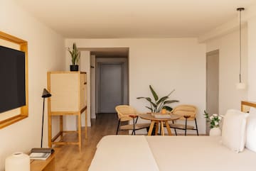 a room with a bed and chairs and a table