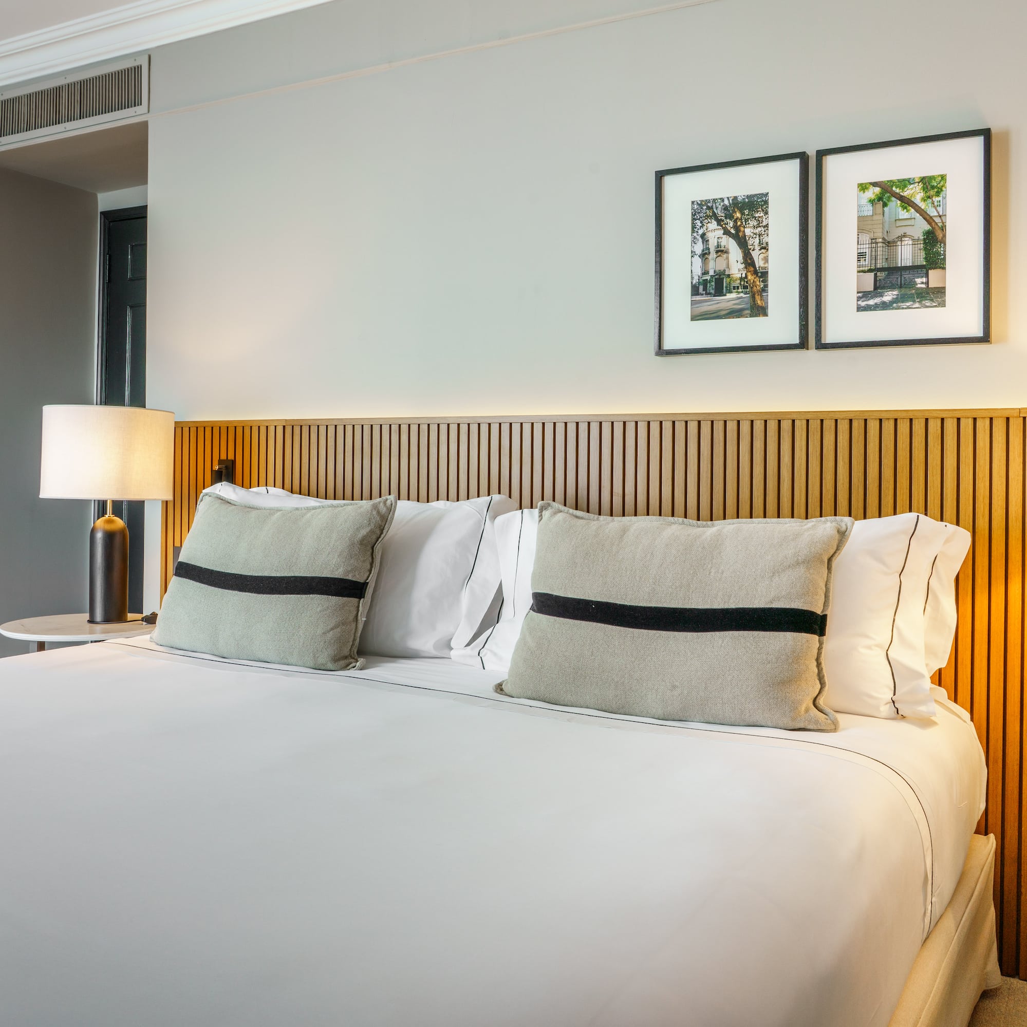 a bed with white sheets and pillows