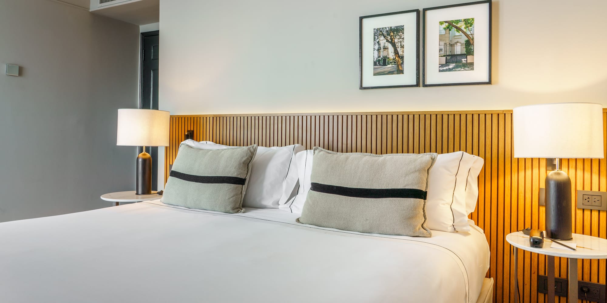 a bed with white sheets and pillows