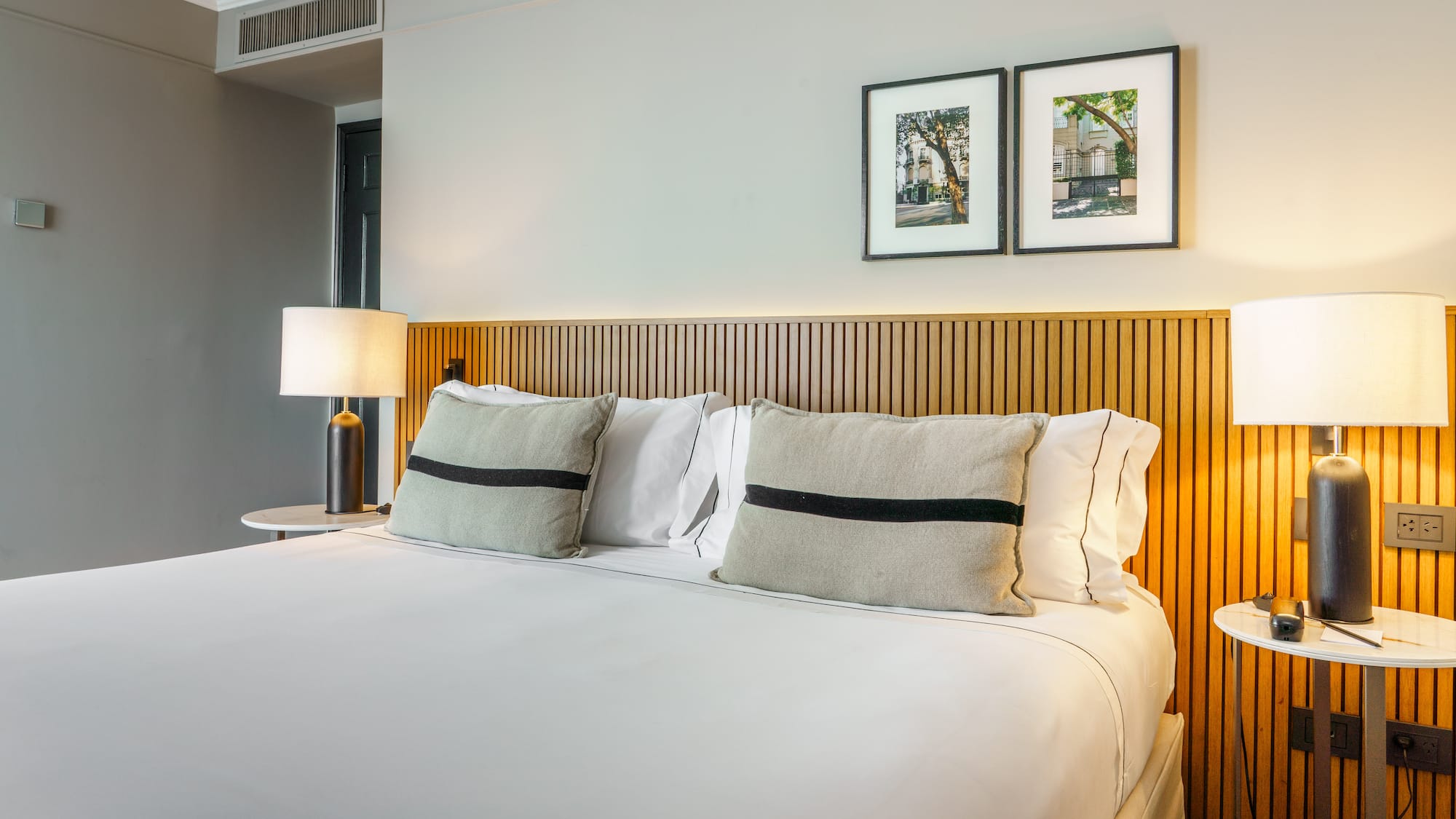 a bed with white sheets and pillows