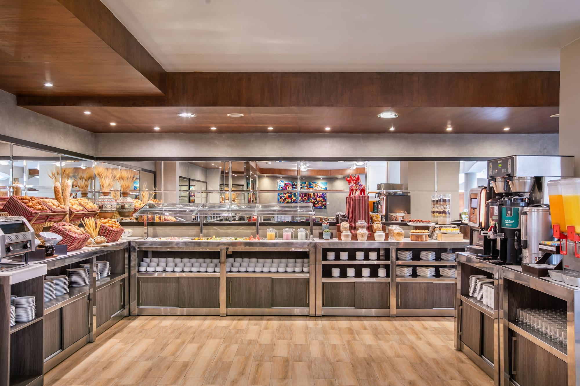 Modern hotel breakfast buffet spread with warm lighting, baked goods, and drinks. - Hotel Cusco La Paccha Affiliated by Meliá, Cusco