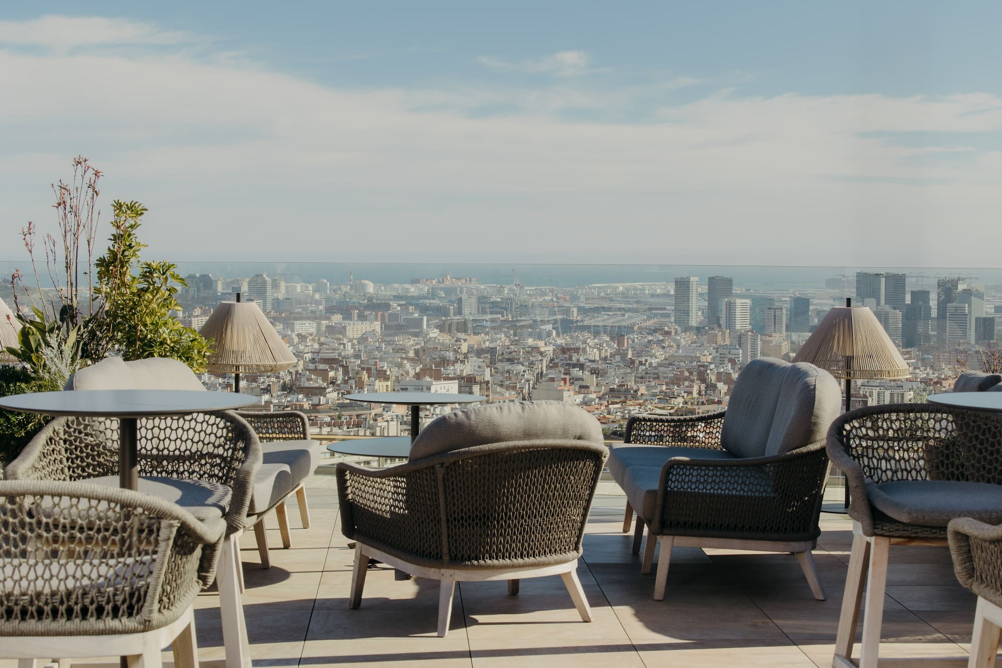 Rooftop terrace with outdoor seating, city panorama, and sea view.