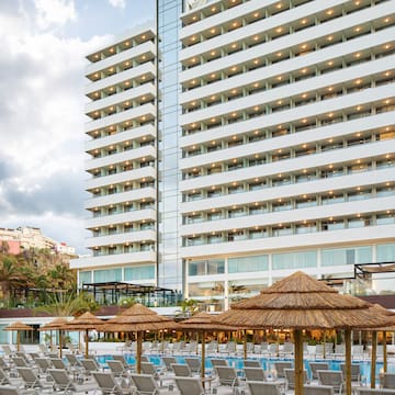 a large building with many chairs and umbrellas