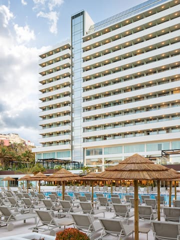a large building with many chairs and umbrellas