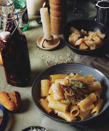 a plate of pasta and a bottle of sauce